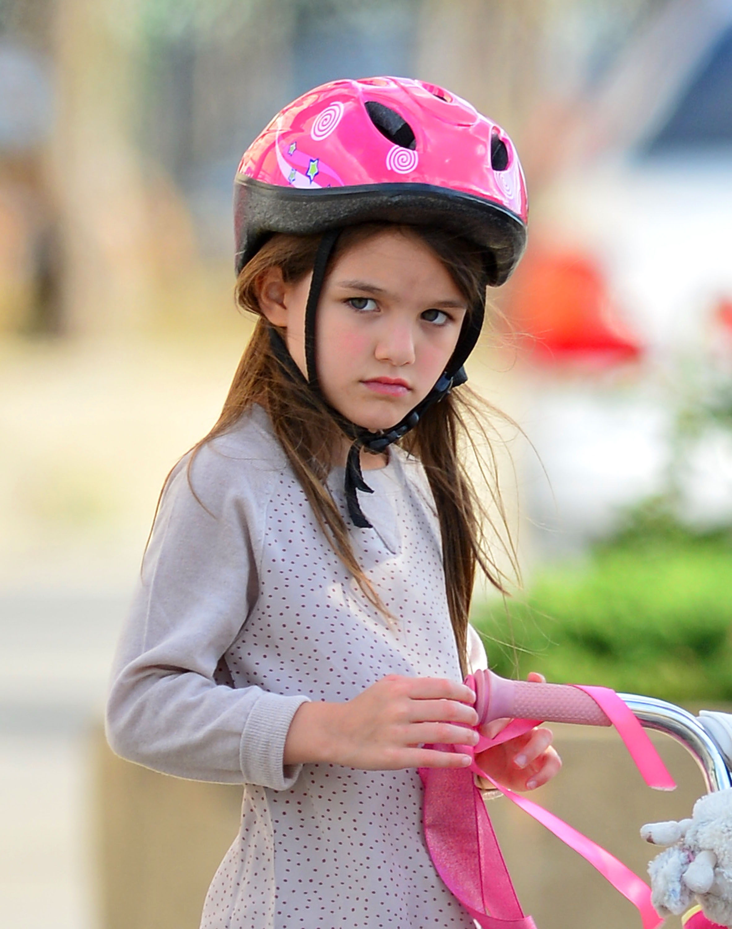 Suri Noelle was photographed riding her bicycle in New York on August 18, 2012, wearing a bright pink helmet as she enjoyed a day outdoors. The image was taken just weeks after Tom Cruise and Katie Holmes finalized their divorce, marking the beginning of a new chapter in which she would be raised primarily by her mother in The Big Apple.