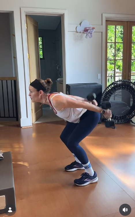 Jennifer Garner wears a white athletic tank top, navy leggings, and running shoes, with a mini trampoline and step platform visible behind her. | Source: Instagram/jennifer.garner