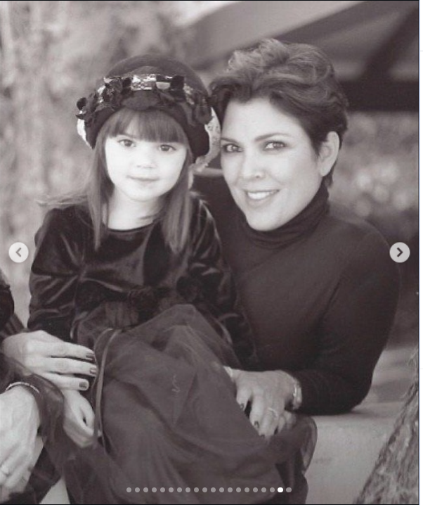 A black-and-white throwback shows Kris Jenner sitting with a young Kendall Jenner on her lap, with the mother and daughter smiling for the camera. | Source: Instagram/krisjenner