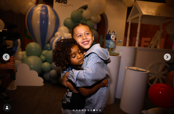 Aeko Brown smiling as he hugs a loved one during a celebration event, posted on November 23, 2023. | Source: Instagram/ammikaaa
