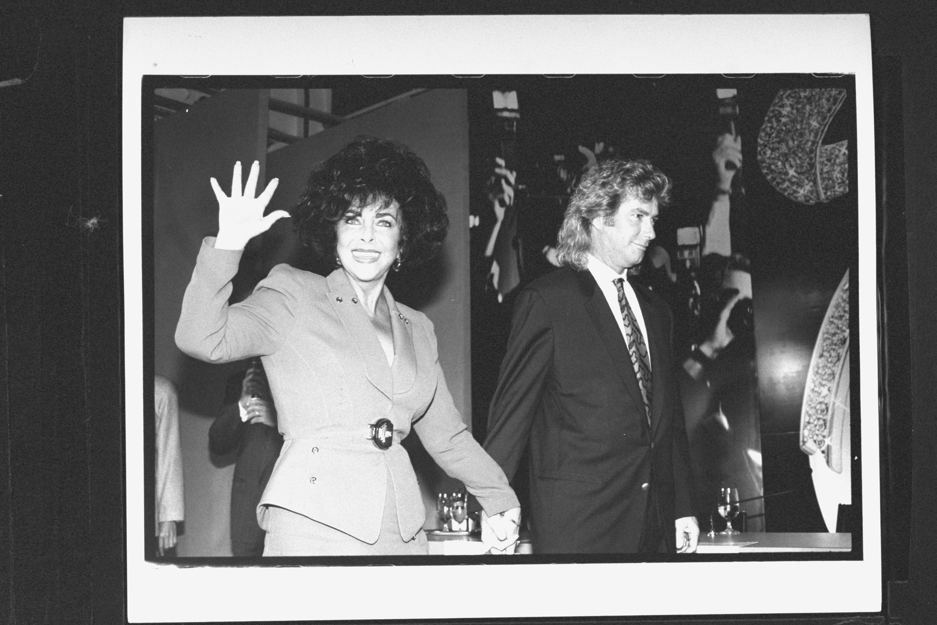 The actress holds hands with fiancé Larry Fortensky and waves at the press on January 1, 1991 | Source: Getty Images