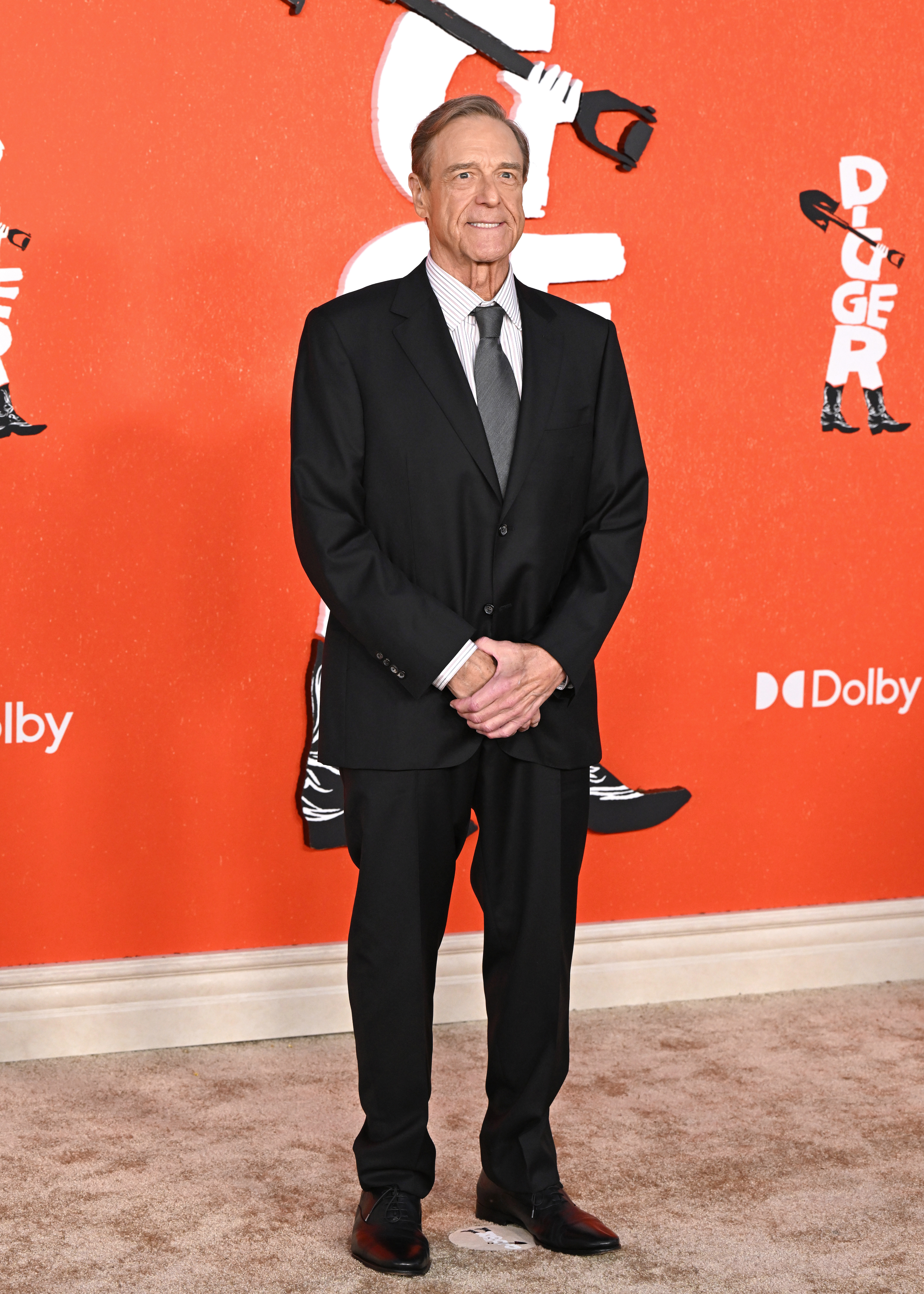 A full-length solo portrait provides the clearest view of Goodman's noticeably lean frame beneath his black suit. The image brings his yearslong physical transformation into sharp focus and helps show why his appearance became a topic of conversation online.
