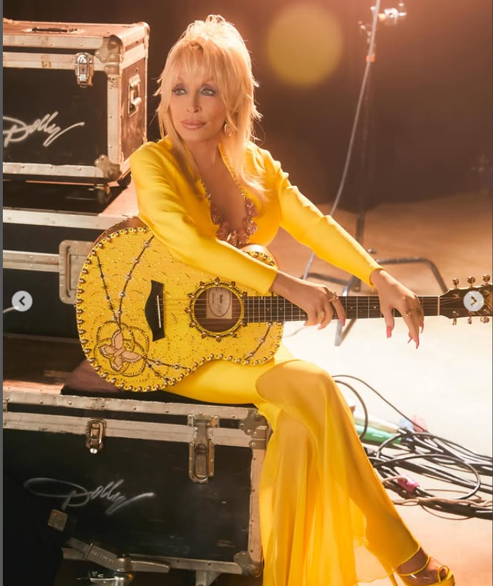 Dolly Parton looks radiant in a yellow dress and a guitar on her lap, from a post dated June 11, 2025 | Source: Instagram/dollyparton