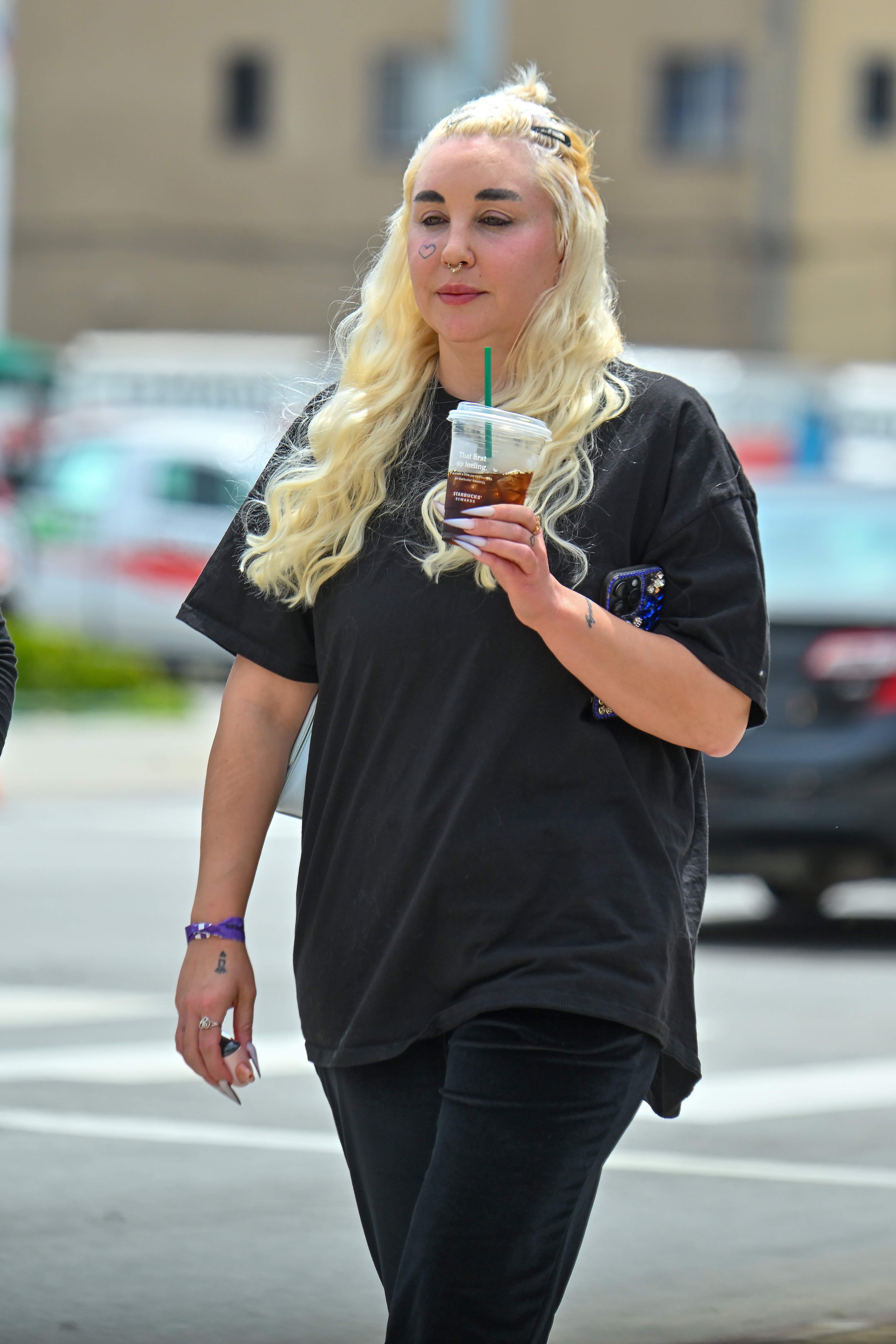 In a later 2024 appearance, Bynes showcased long platinum waves, dark brows, facial piercings, and visible tattoos while keeping her outfit casual with an oversized black T-shirt and leggings.