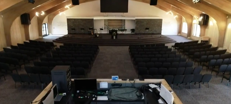 Rows of chairs faced a raised stage inside the completed sanctuary, demonstrating one of the most significant changes made to Mike Tyson's former estate. The vast gathering space incorporated screens, musical equipment, lighting, and stone accents as Living Word Sanctuary Church adapted the mansion for worship, turning an area associated with the property's extravagant past into a functional setting for its expanding congregation. | Source: YouTube/WKYC Channel 3