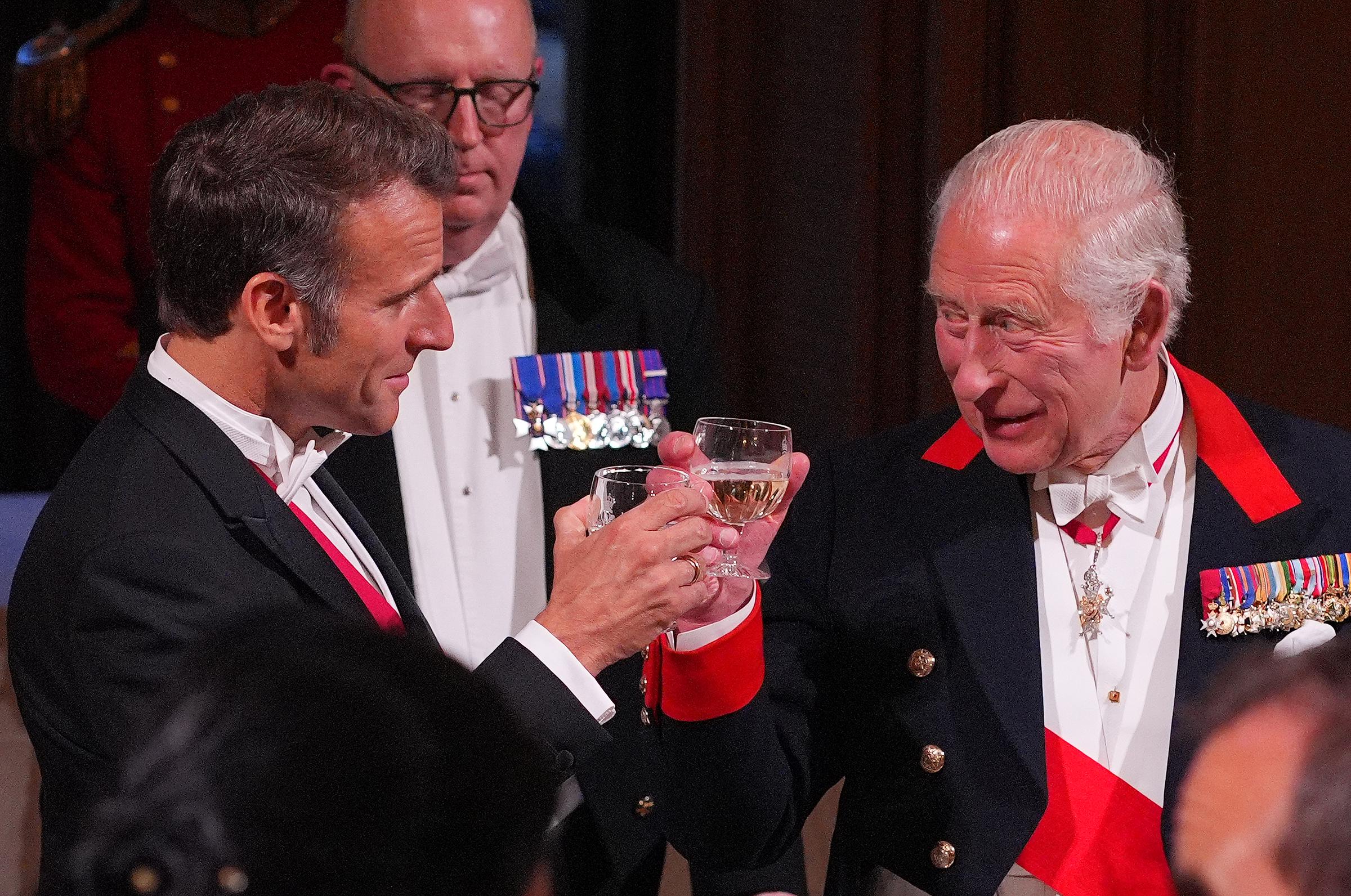 France's President clinks wine glasses with King Charles during the banquet in Windsor Castle, west London. The French President gives off that French charm.