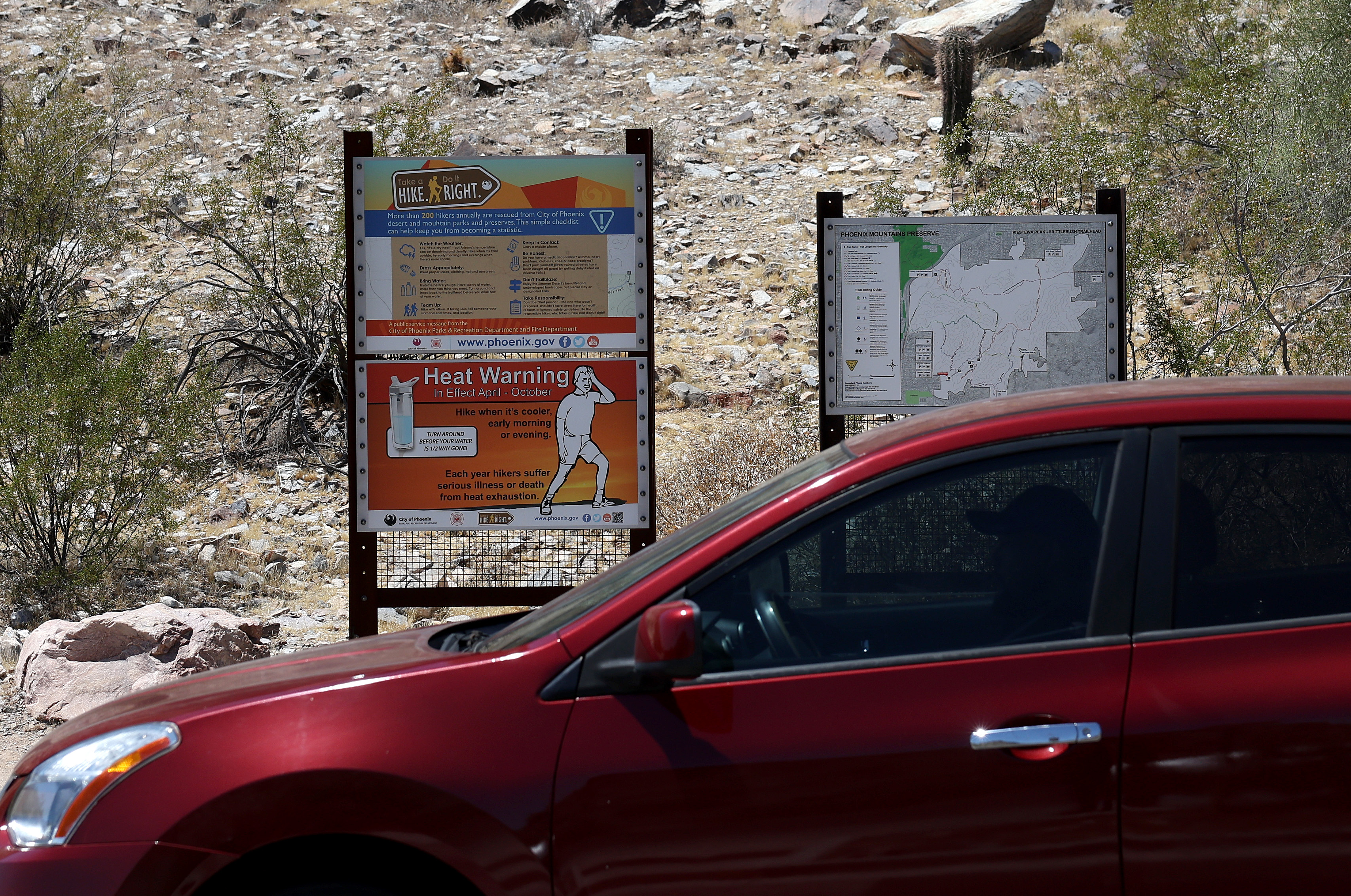 Warning signs posted at a Phoenix trailhead caution hikers about extreme heat risks Source: Getty Images