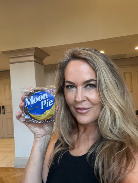 Another selfie shows Murphy indoors, holding a packaged Moon Pie beside her face while wearing a black top. The playful image gives a more casual look at her than the polished car selfie that drew so much reaction. | Source: Instagram/erinmurphybewitched