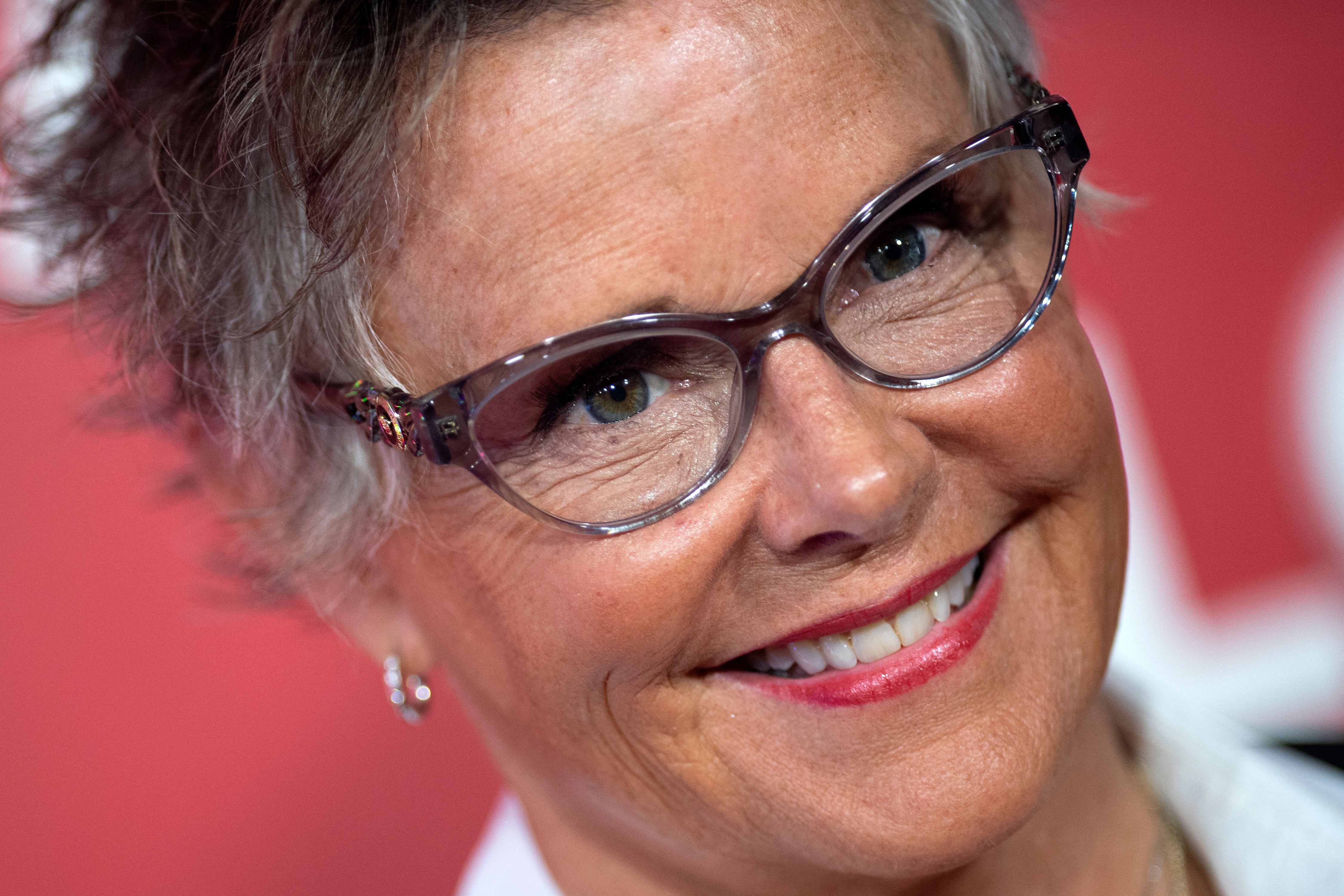 Amanda Bearse flashed a cheerful, crinkled smile in a close-up portrait while arriving for the premiere of Universal Pictures' "Bros" at Regal LA Live on September 28, 2022, in Los Angeles, California. The actress and director wore stylish cat-eye glasses with translucent purple frames, showcasing her cropped salt-and-pepper pixie cut and a bold berry-red lipstick. | Source: Getty Images