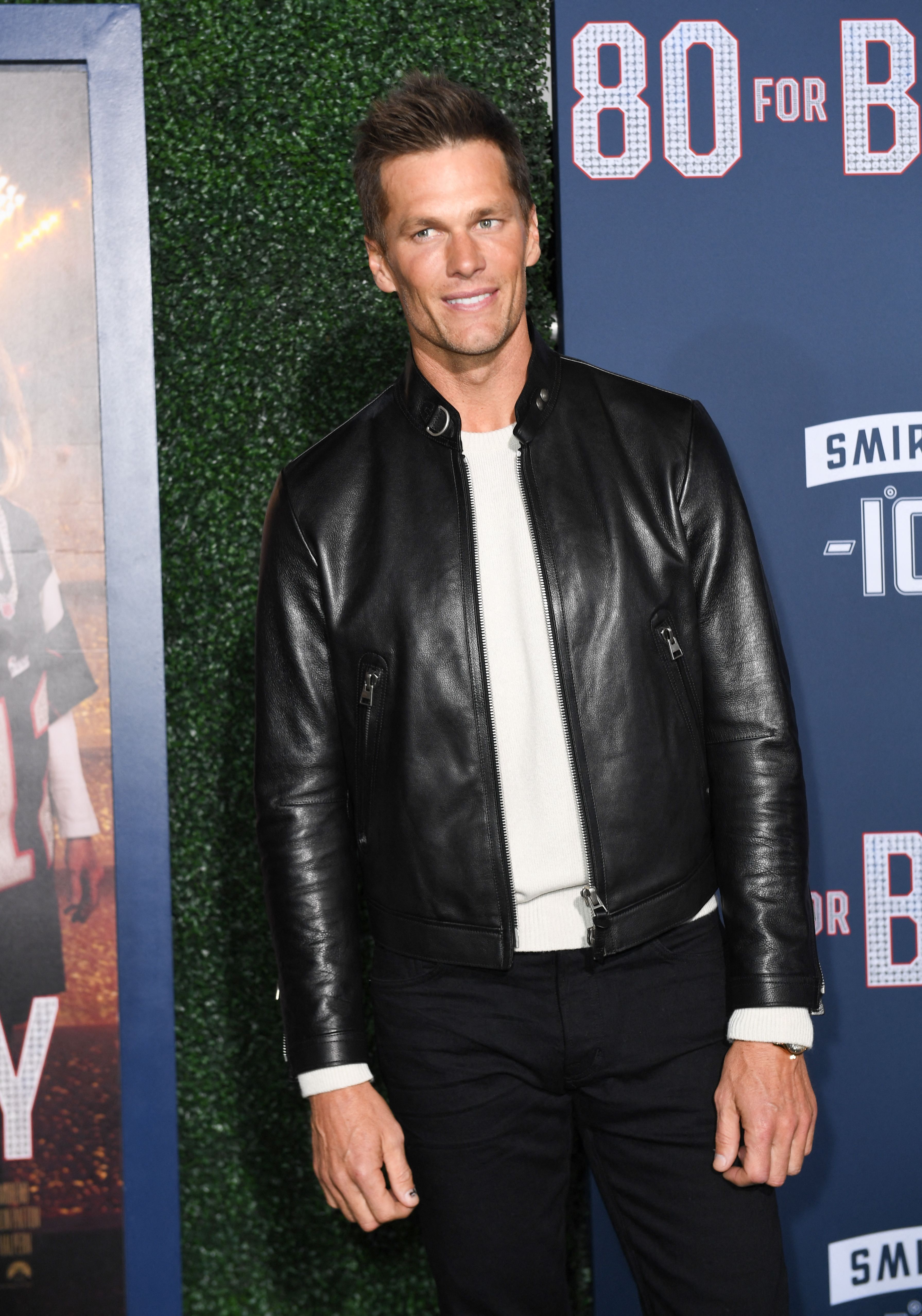 Away from the football field, Tom Brady still turns heads. He rocked a black leather jacket over a white tee and black trousers at the premiere screening of "80 For Brady" at the Regency Village Theatre in Los Angeles, California.