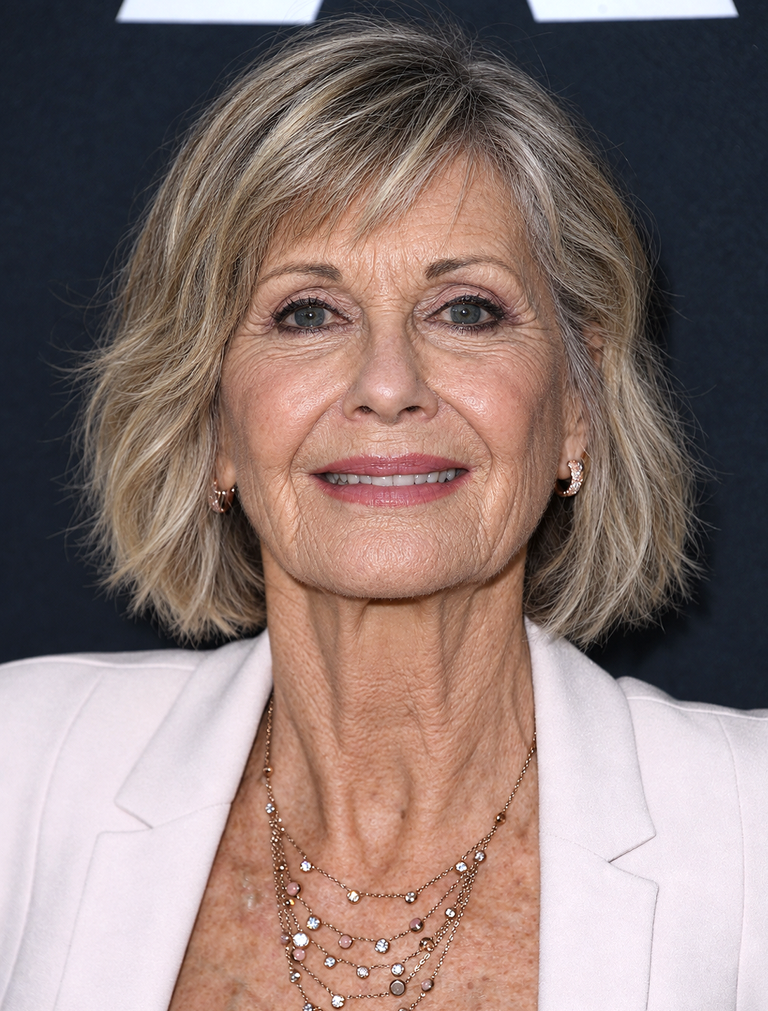 AI-generated impression. The imagined 76-year-old Olivia appears polished and poised, as though stepping back into the public appearances she made for decades. It offers another hypothetical glimpse at the aging the real Olivia never had the opportunity to experience. | Source: Chat GPT