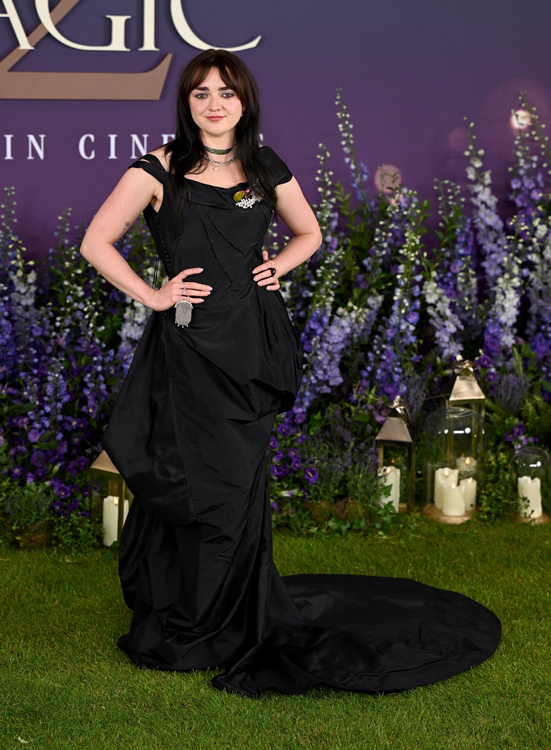 Maisie Williams embraced the dark, witchy mood of Practical Magic 2 in a floor-length black gown as she posed at the film's London photocall, with the candlelit floral setting adding to the sequel's mystical atmosphere. | Source: Getty Images