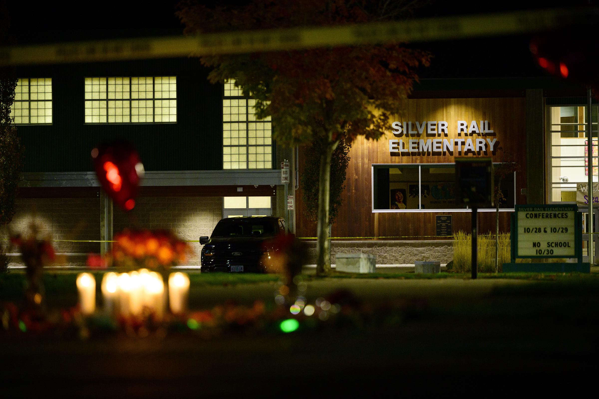 Silver Rail Elementary School is seen at night as candles and flowers create a memorial in the foreground. | Source: Getty Images