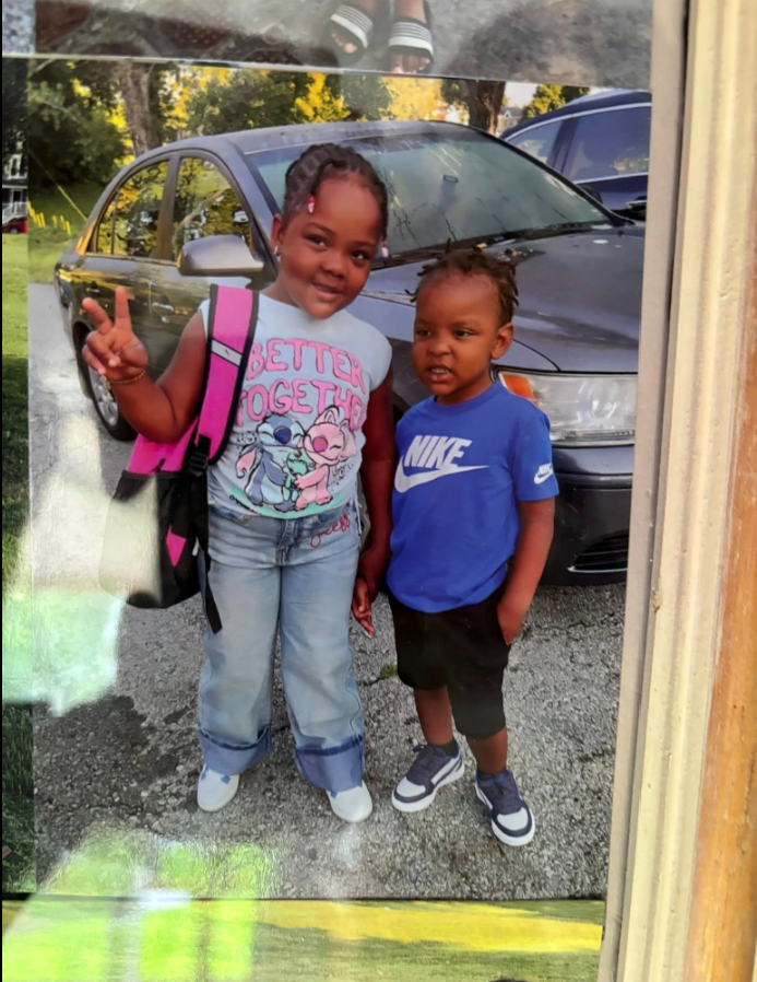 Tadens Joseph stands beside another child in front of a parked car while posing for a photo outdoors. | Source: Facebook/Eric Graves﻿