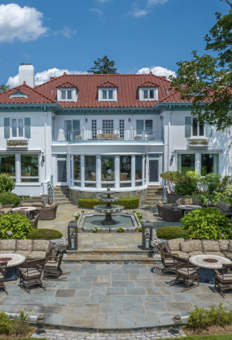 Kathie Lee Gifford's Connecticut estate features a Mediterranean-style exterior, a red-tiled roof, and a beautifully landscaped terrace with outdoor seating and a fountain — just one glimpse of the home she spent 32 years transforming | Source: Instagram/ @sothebysrealty