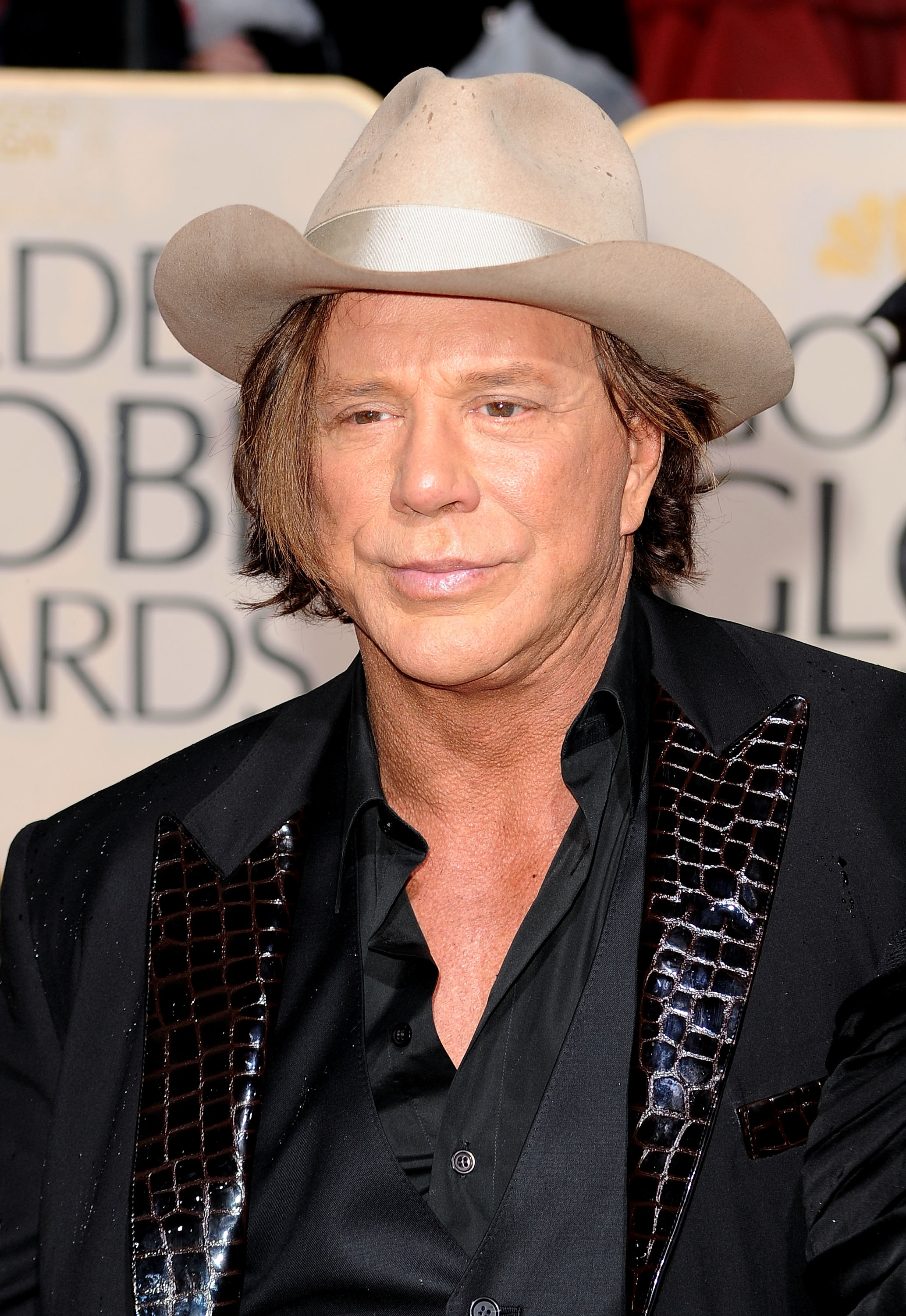 Mickey Rourke arrives at the 67th Annual Golden Globe Awards in Beverly Hills, exuding his signature bold style. Dressed in a sleek black suit with textured accents and a cream cowboy hat, he blends rugged charm with Hollywood flair.
