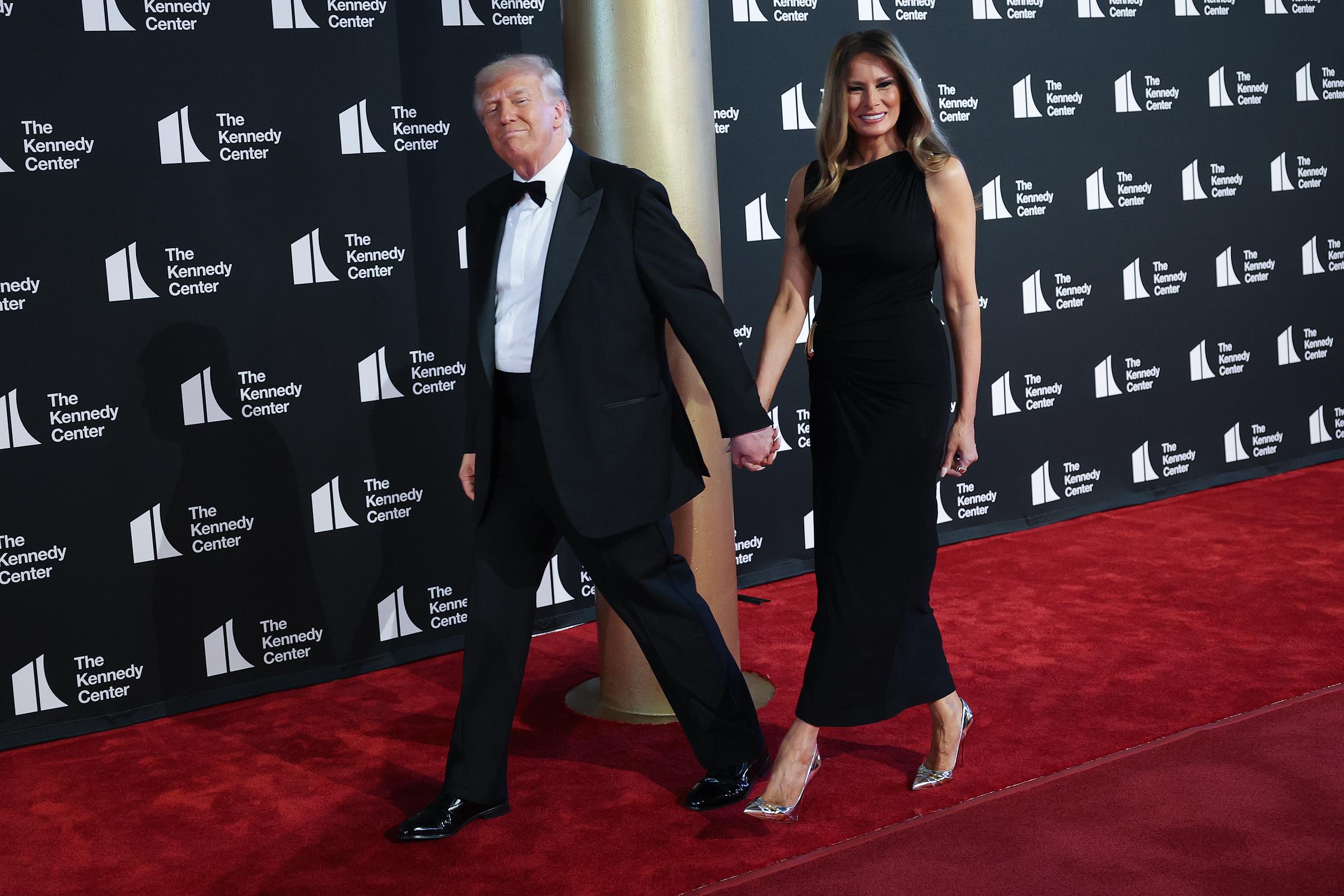 Walking side by side, the president and first lady pose confidently on the red carpet, offering composed expressions as they arrive for the musical's opening night in Washington, D.C.