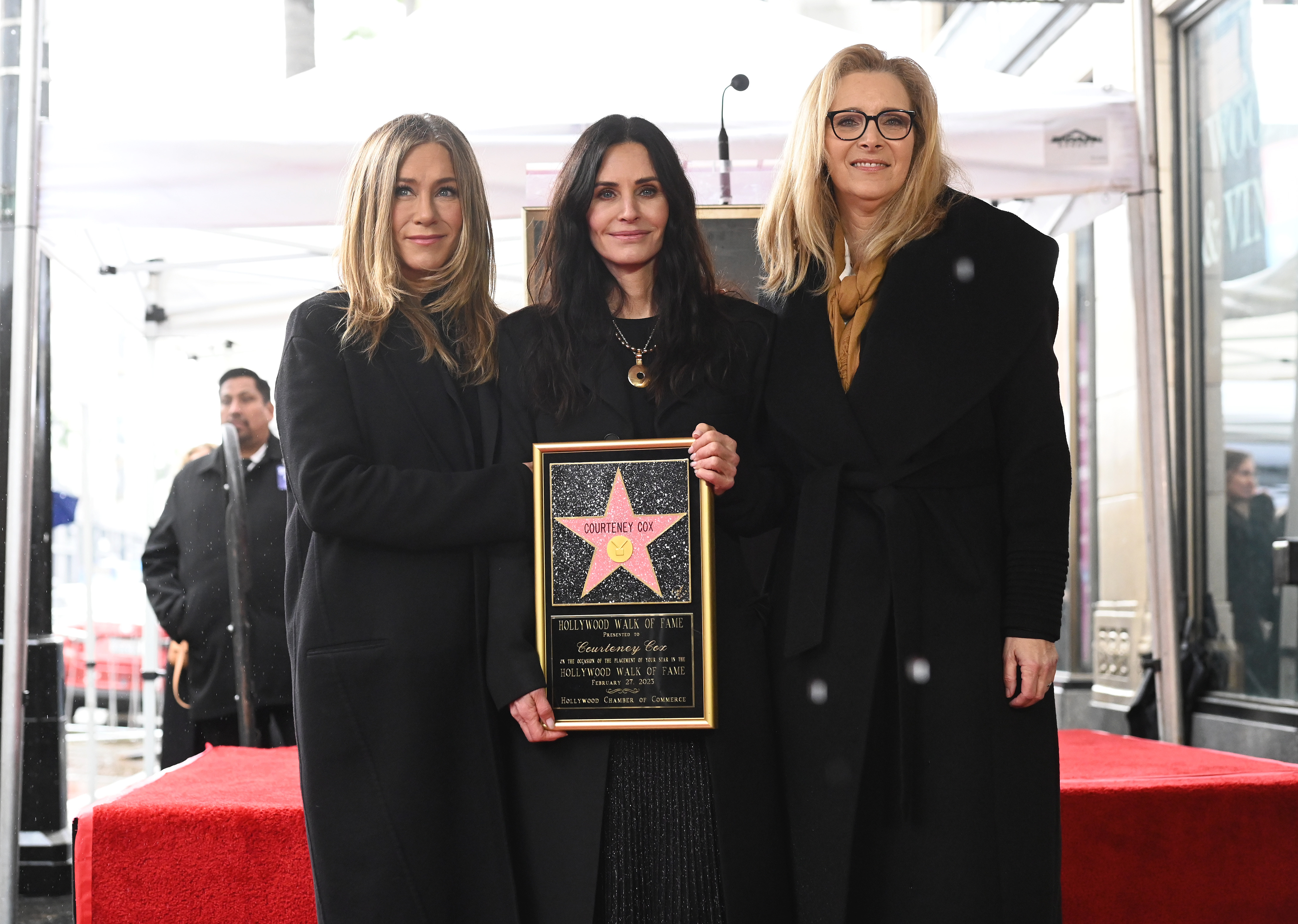 Jennifer Aniston and Courteney Cox are joined by Lisa Kudrow at the ceremony honoring Cox with a star on the Hollywood Walk of Fame in Los Angeles, California. The trio don their signature all-black attire, with Aniston and Kudrow beaming proudly as Cox stands between them holding her star.