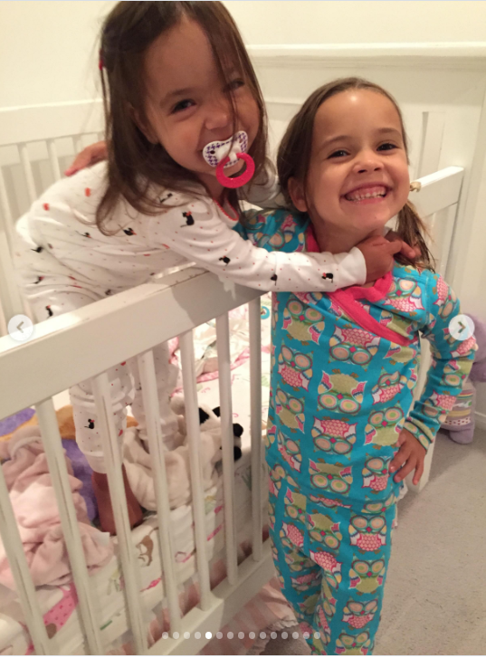 turning an ordinary bedtime scene into a snapshot of their relationship. Mabel and Fiona share an affectionate moment in their childhood bedroom, with Fiona leaning over the white crib in white pajamas and a pacifier while Mabel smiles beside her in bright blue patterned pajamas. The sisters appear completely at ease together, capturing a sweet glimpse of their bond during childhood. | Source: Instagram/mabellowe_
