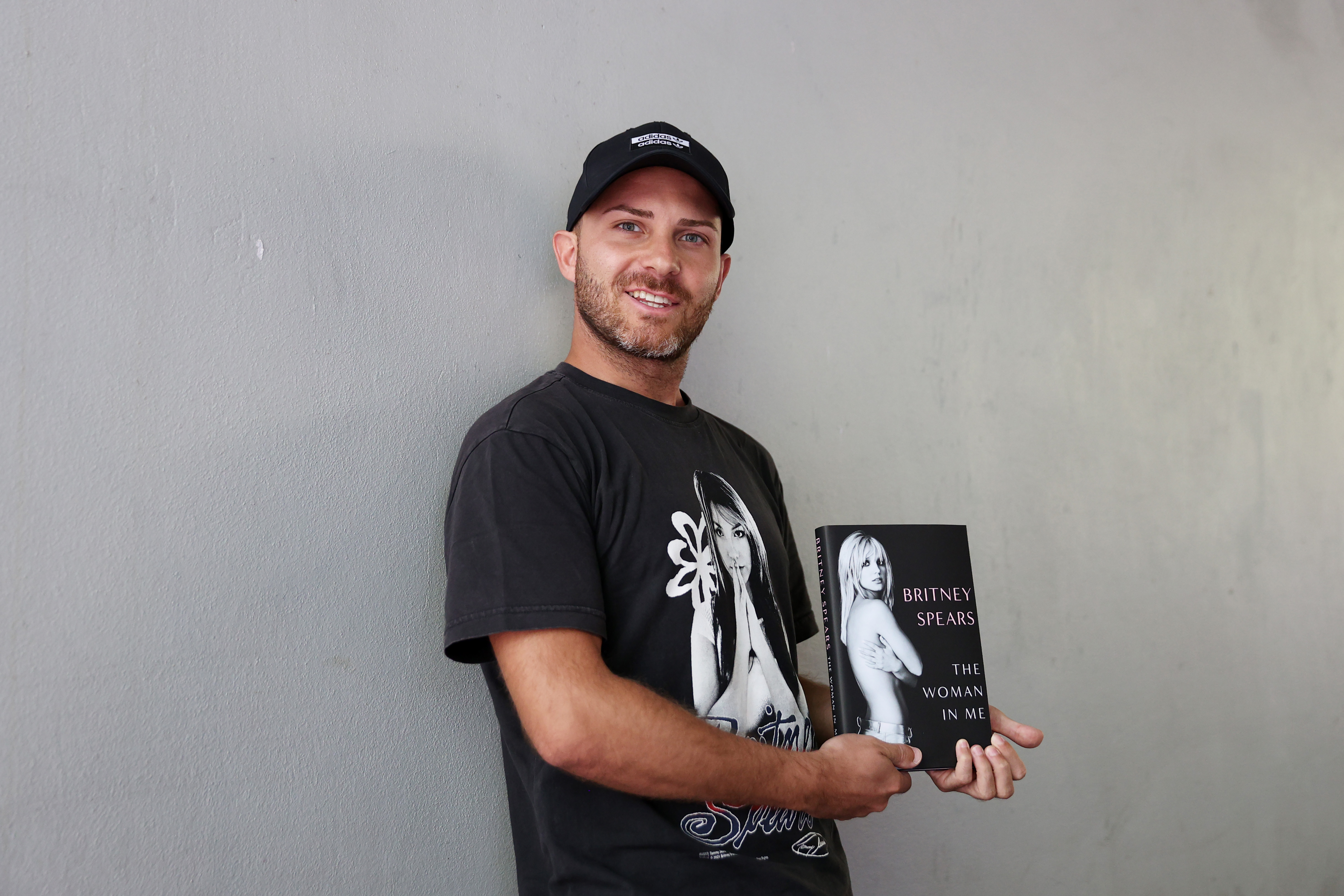 Marco Biras with a copy of Britney Spears's memoir "The Woman in Me" at a fan event in Sydney, Australia on October 25, 2023. | Source: Getty Images