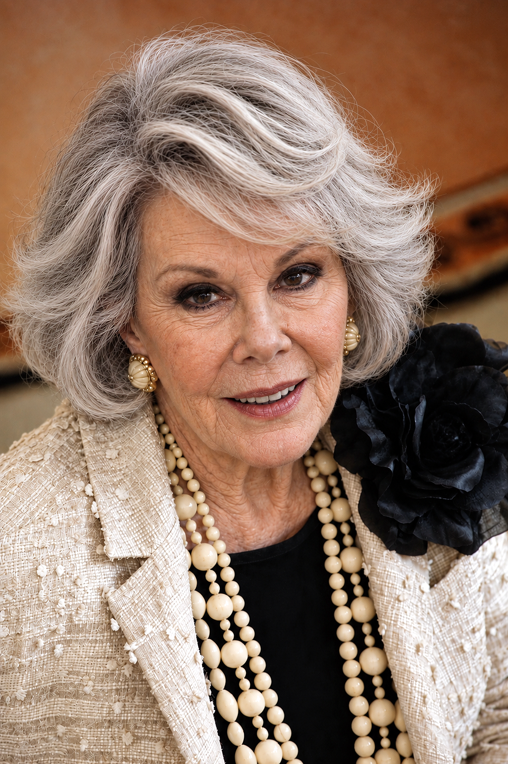In this AI-generated version, Joan appears with silver-gray hair, visible facial lines, and softer contours, complemented by pearl jewelry and a cream jacket. | Source: ChatGPT