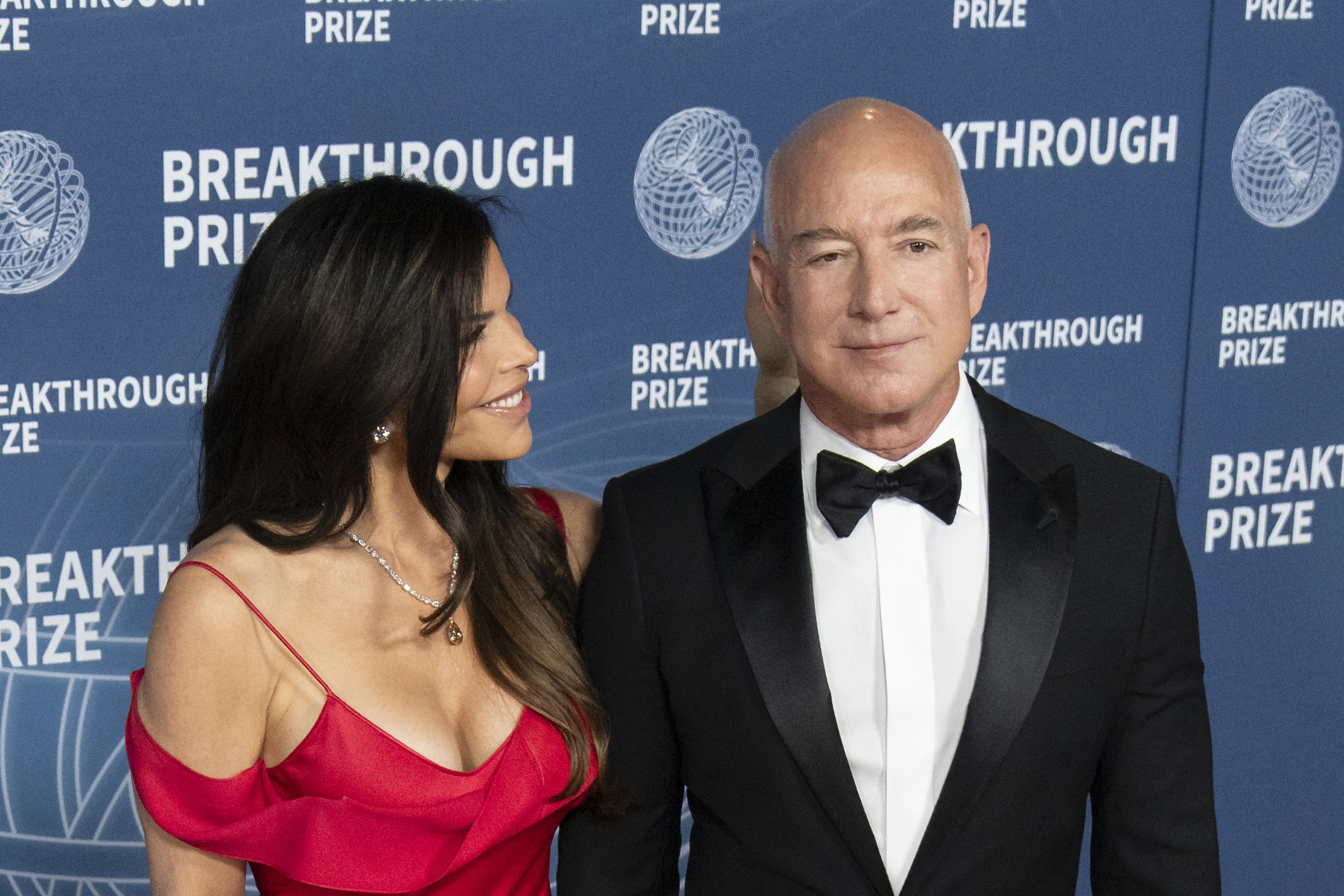 Lauren Sanchez looks toward Jeff Bezos as they pose on the arrivals carpet at the 2025 Breakthrough Prize Ceremony on April 5, 2025, in Santa Monica, California | Source: Getty Images