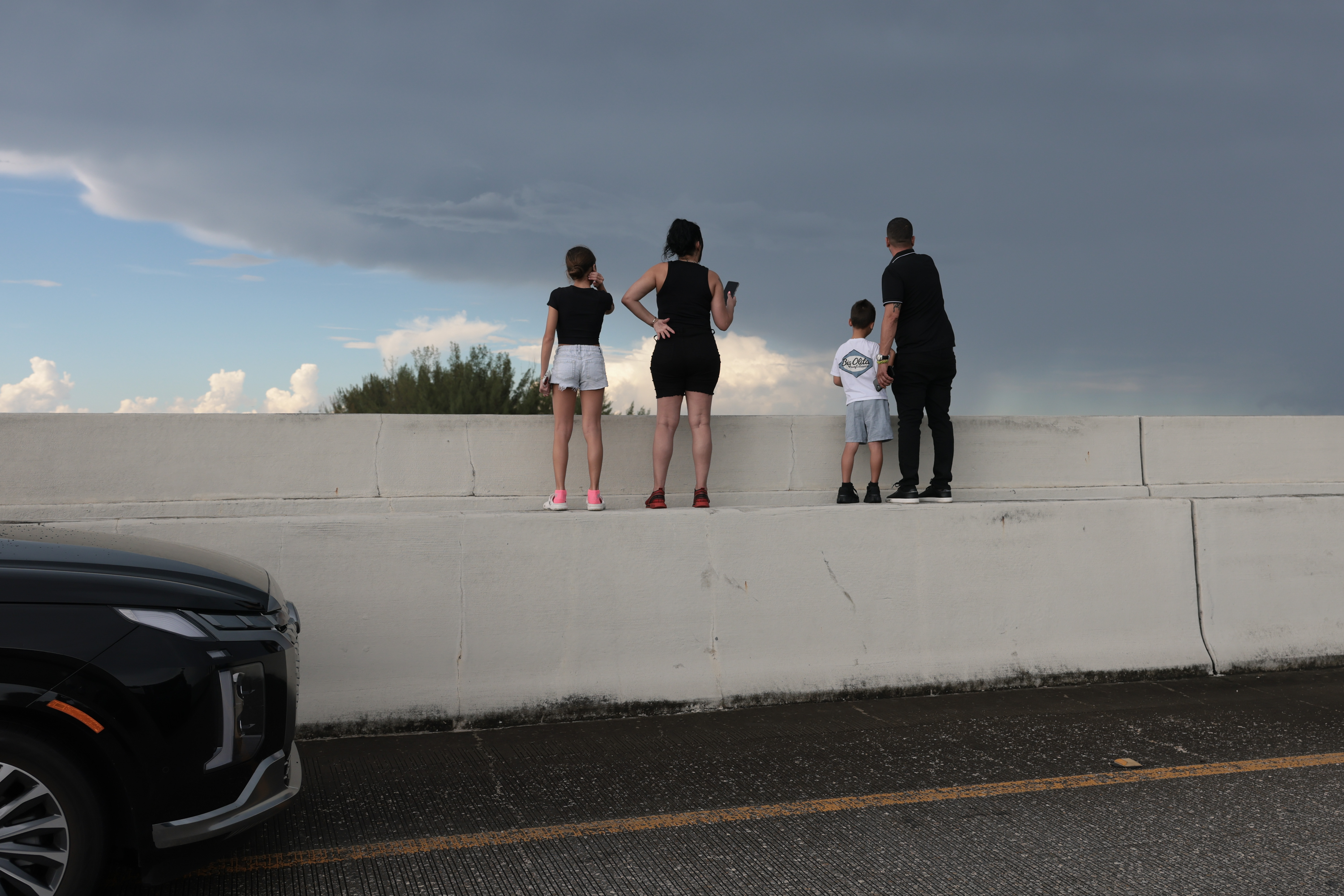 eople stopped along a roadway to look toward the crash scene as the emergency unfolded near Miami International Airport. The incident disrupted airport operations, with runways and taxiways temporarily closed and a full ground stop put into effect. | Source: Getty Images