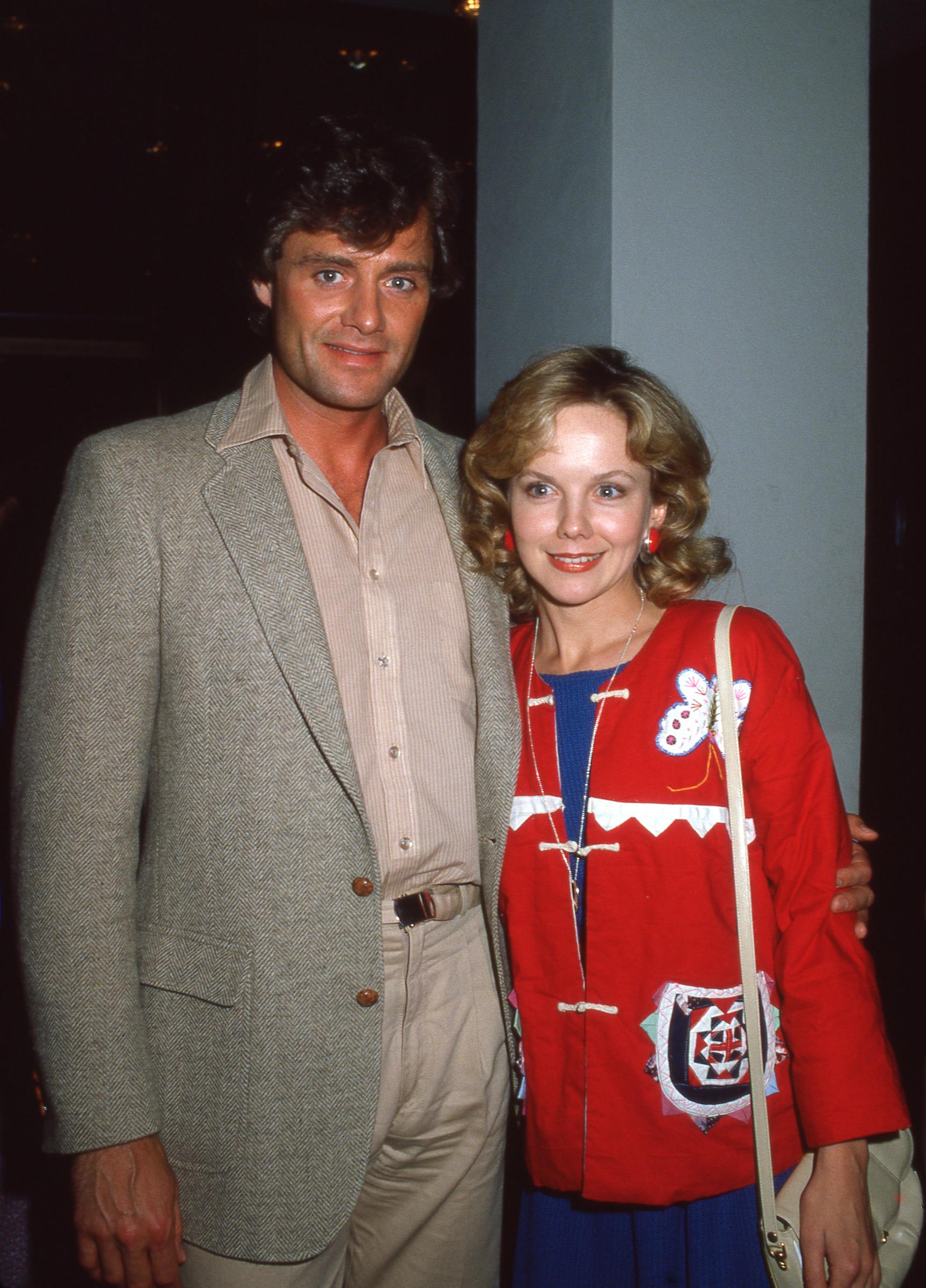 Posing alongside Duncan Regehr in 1984, 28-year-old Linda Purl showcased an eclectic mid-1980s style with bright red button earrings and a vibrant red mandarin-collared jacket adorned with butterfly appliqués. Her shoulder-length honey curls and soft curtain bangs framed cheekbones that had grown noticeably more sculpted, accentuating a warm, confident smile that signaled her blossoming maturity. | Source: Getty Images