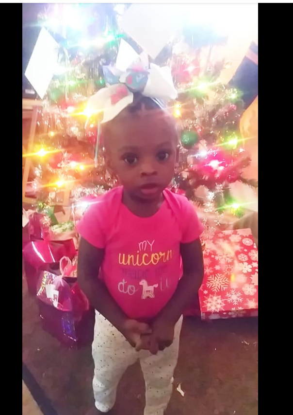 A photo of one of Shamar Elkins’s children shows her standing in front of a brightly lit Christmas tree, surrounded by colorful presents. | Source: Facebook/Shaneiqua Elkins