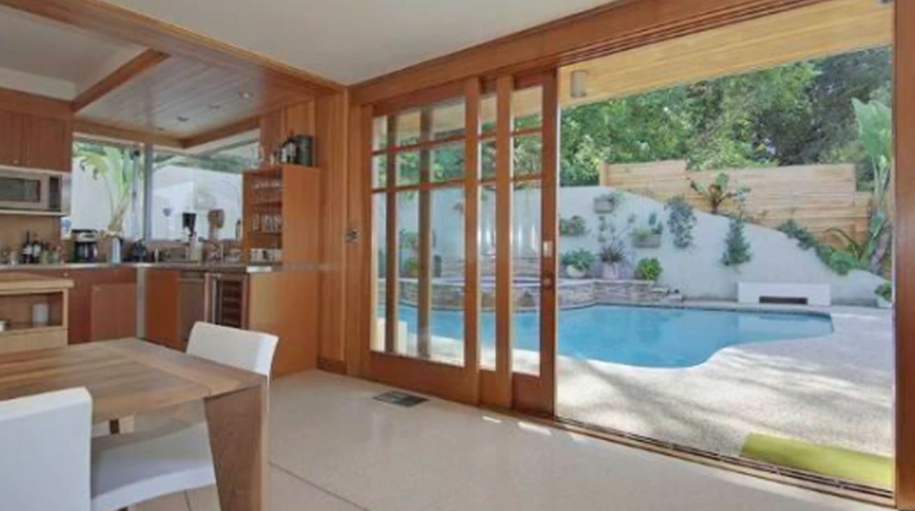 Indoor-outdoor living is one of the property's strongest features. The kitchen and dining areas open toward the backyard, making the pool feel like an extension of the interior.