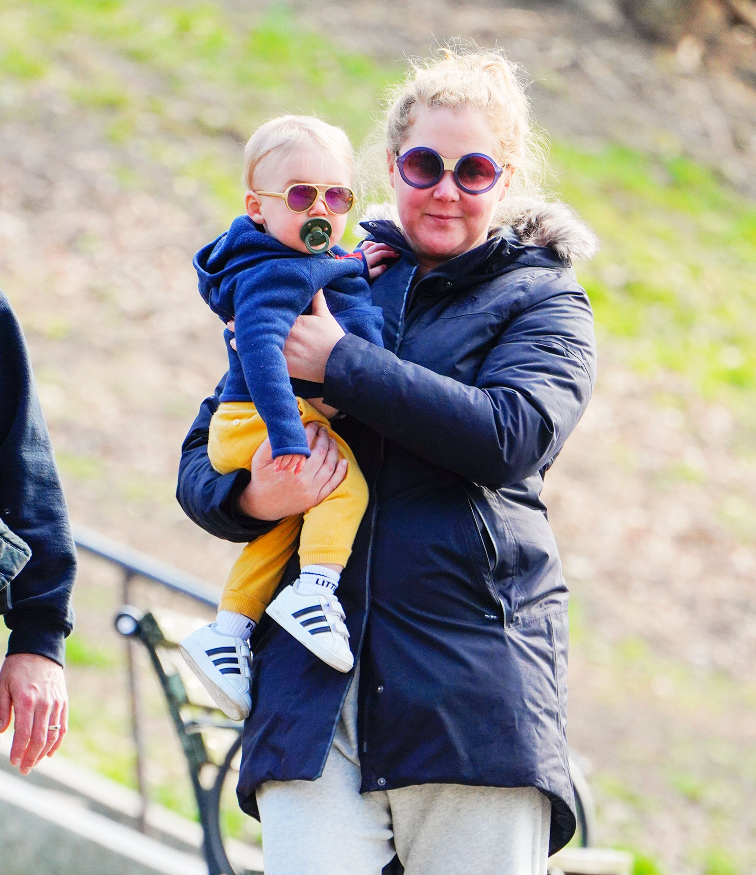 Amy Schumer steps out for a walk while carrying her son Gene Fischer. Both are bundled up in jackets and sunglasses as they enjoy a bit of morning air.