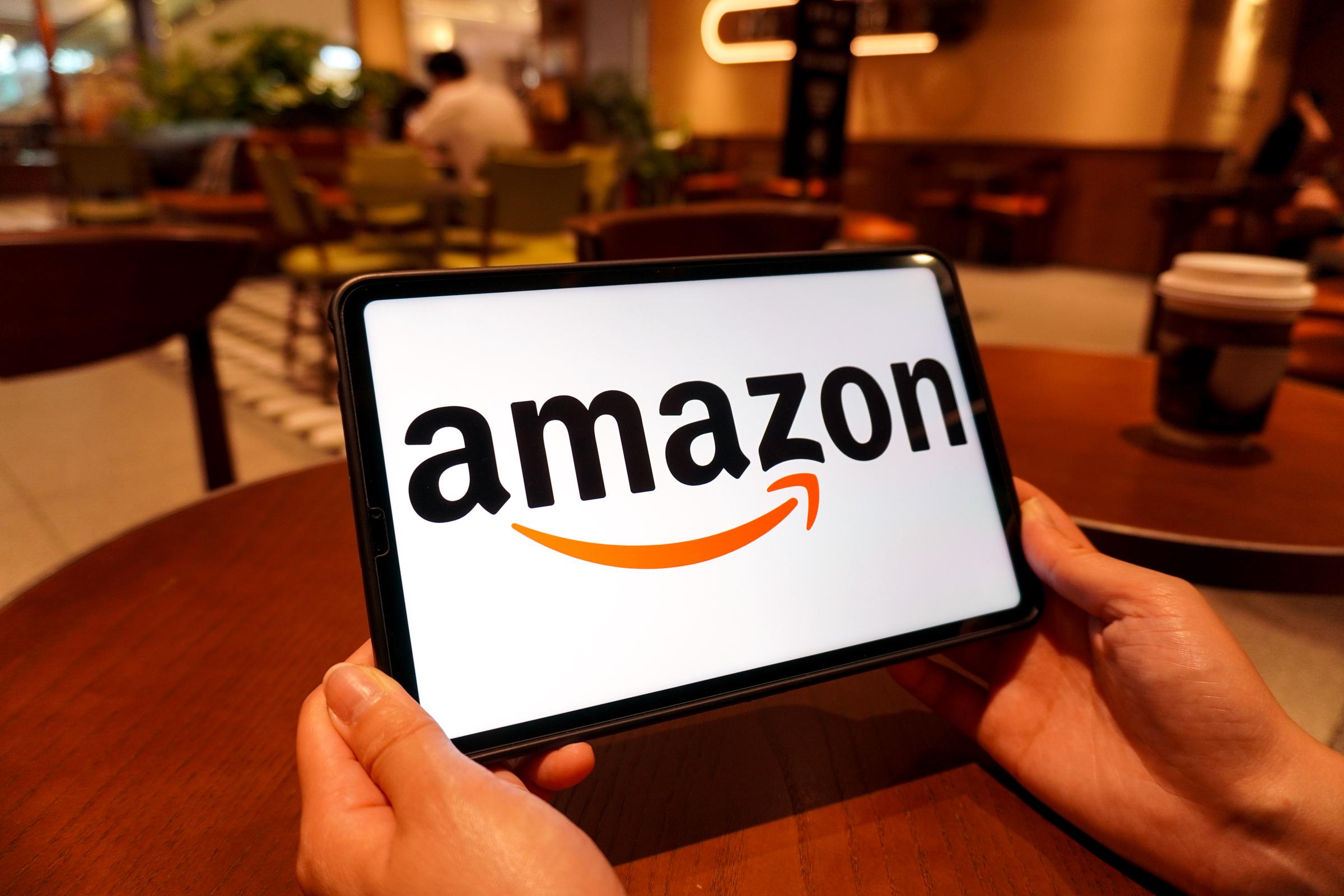 An Amazon logo is displayed on the screen of a smart tablet. | Source: Getty Images