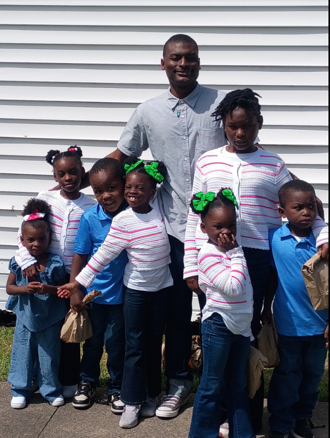 A posed but telling family portrait: Shamar stands at the center, surrounded by his children, some smiling brightly, others more reserved. | Source: Facebook/Shamar Elkins