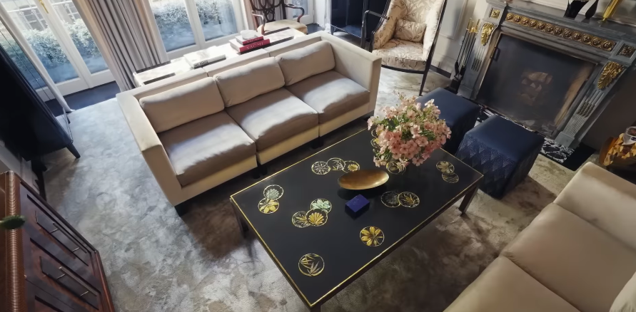 The living room is one of the clearest examples of the home's balance between old-world polish and family comfort. It feels formal enough for a magazine spread, but still soft enough to gather in. | Source: YouTube/Architectural Digest