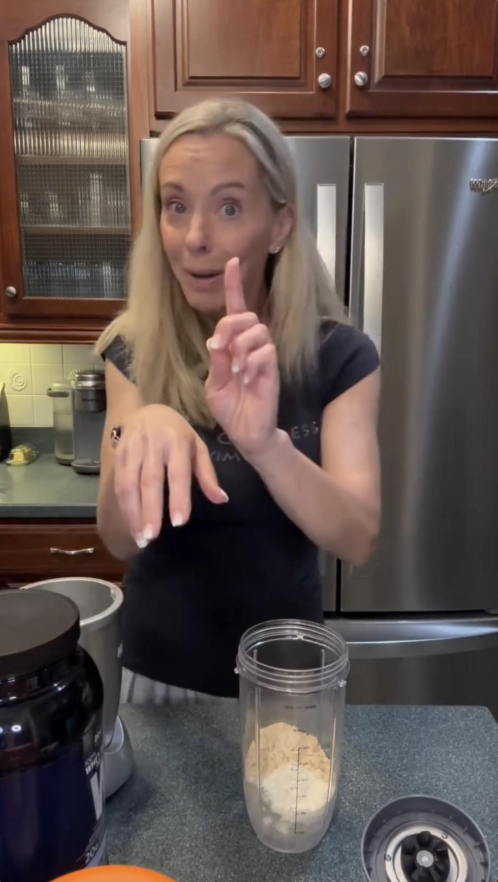 In her kitchen, Kate Gosselin speaks mid-sentence, standing beside a blender filled with protein powder. She gestures playfully as she walks viewers through her smoothie-making routine. | Source: Instagram/kateplusmy8