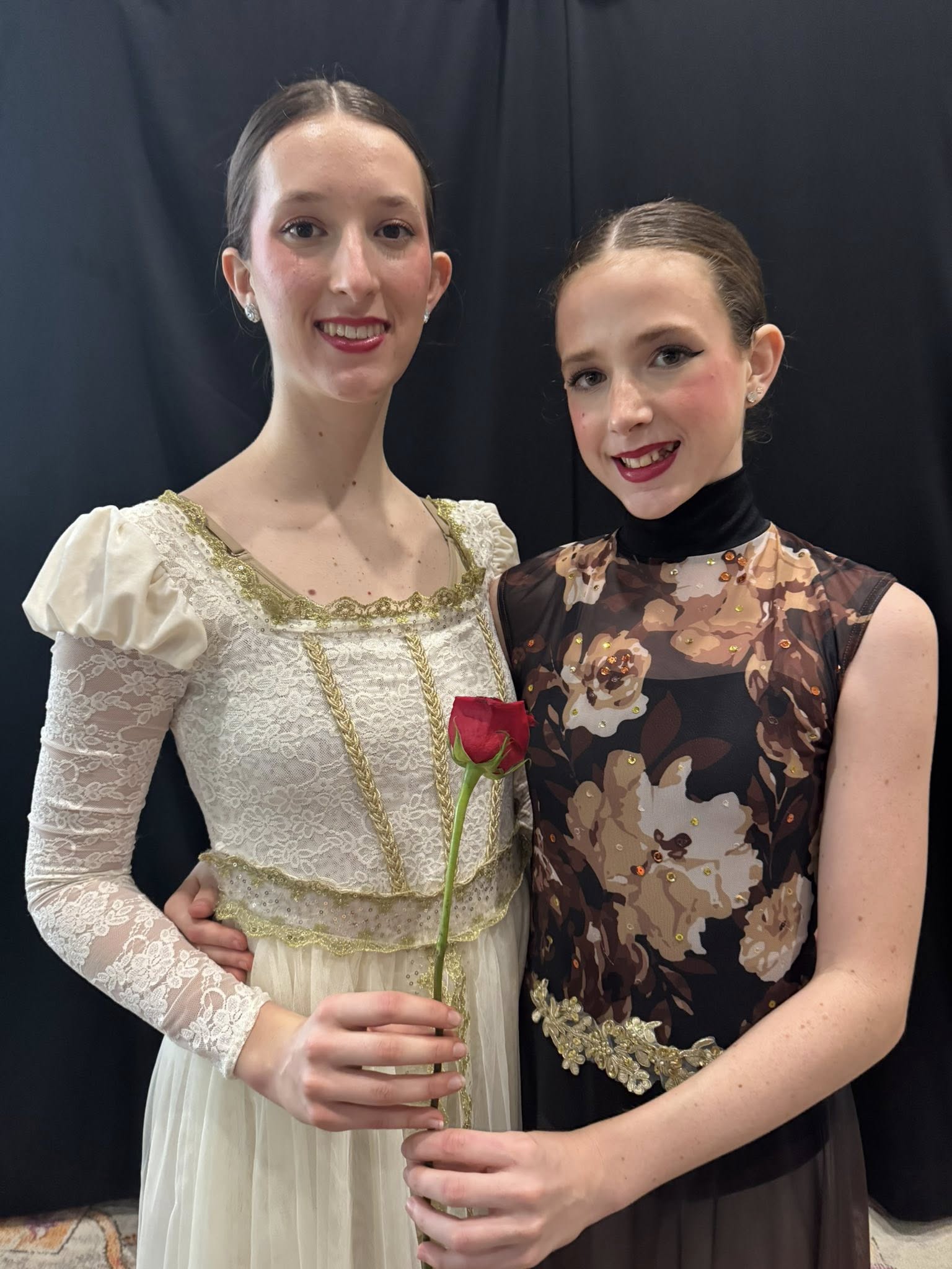 Malaya and Surya Hammond holding a rose and smiling before a dark background circa May 2025. From a post dated June 25, 2025. | Source: Facebook/elizabeth.m.hammond