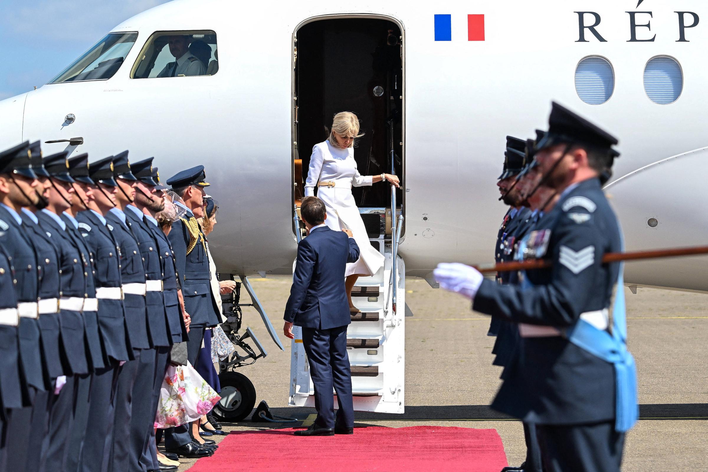 Emmanuel Macron extends his hand to his wife, Brigitte as she descends the aircraft stairs in Britain on July 8, 2025 | Source: Getty Images