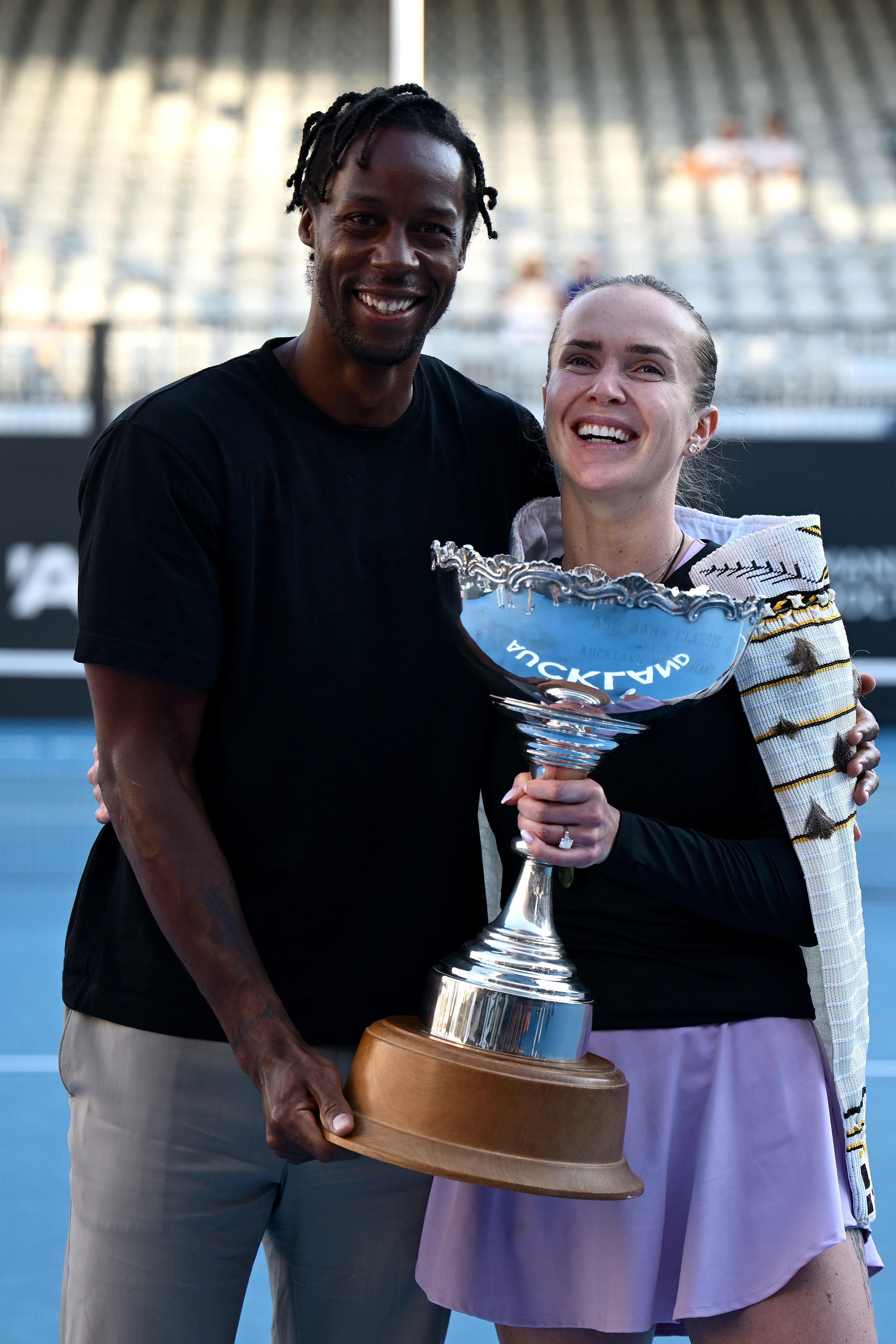 Elina Svitolina and Gaël Monfils share a joyful moment at the ASB Tennis Centre in Auckland, New Zealand on January 11, 2026. Monfils joins his wife on court to celebrate her 2025 ASB Classic victory, a moment of triumph for their tennis family.