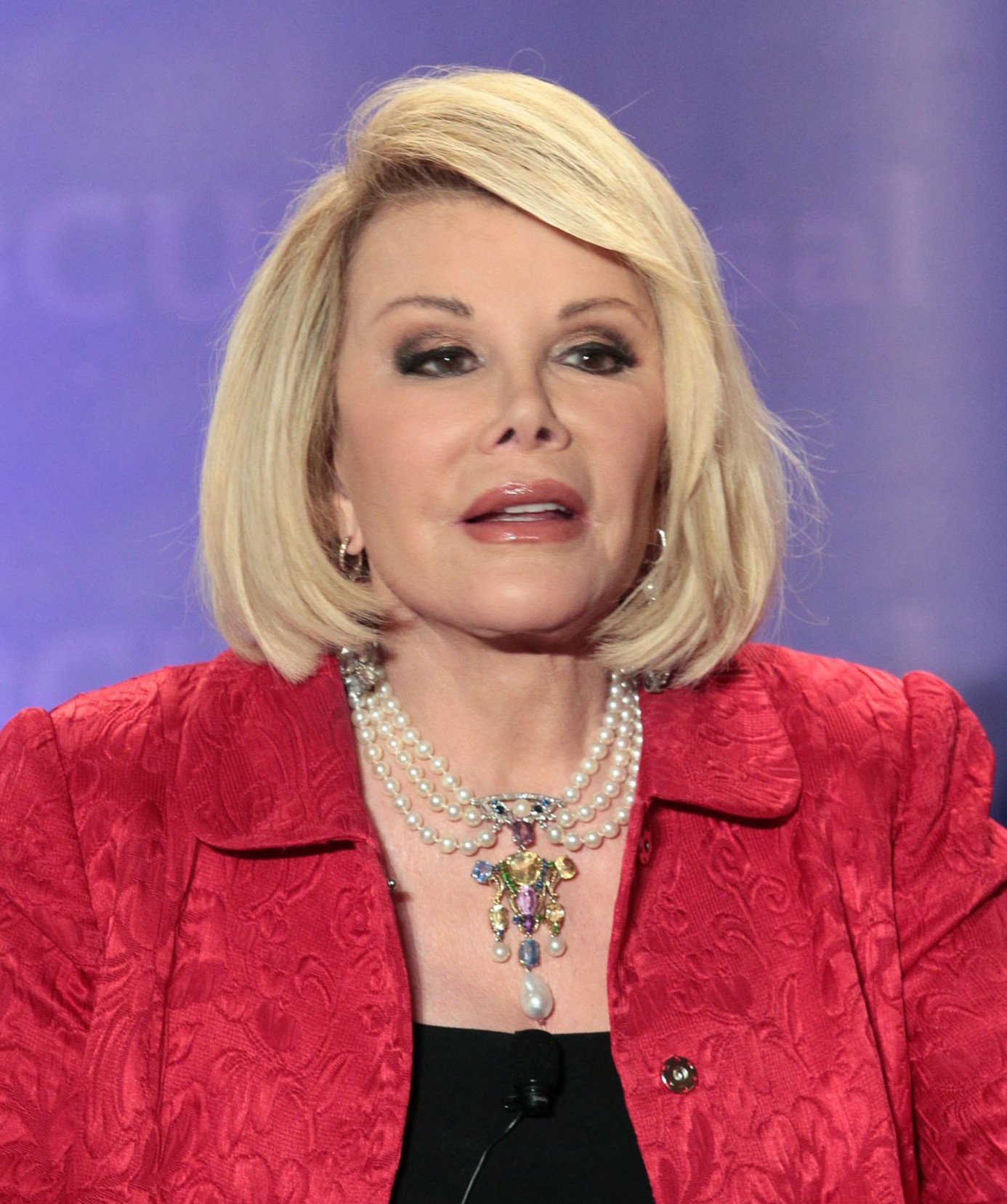 Joan appears with voluminous blonde hair, dark eye makeup, glossy lips, and a smooth complexion in the original photograph. | Source: Getty Images