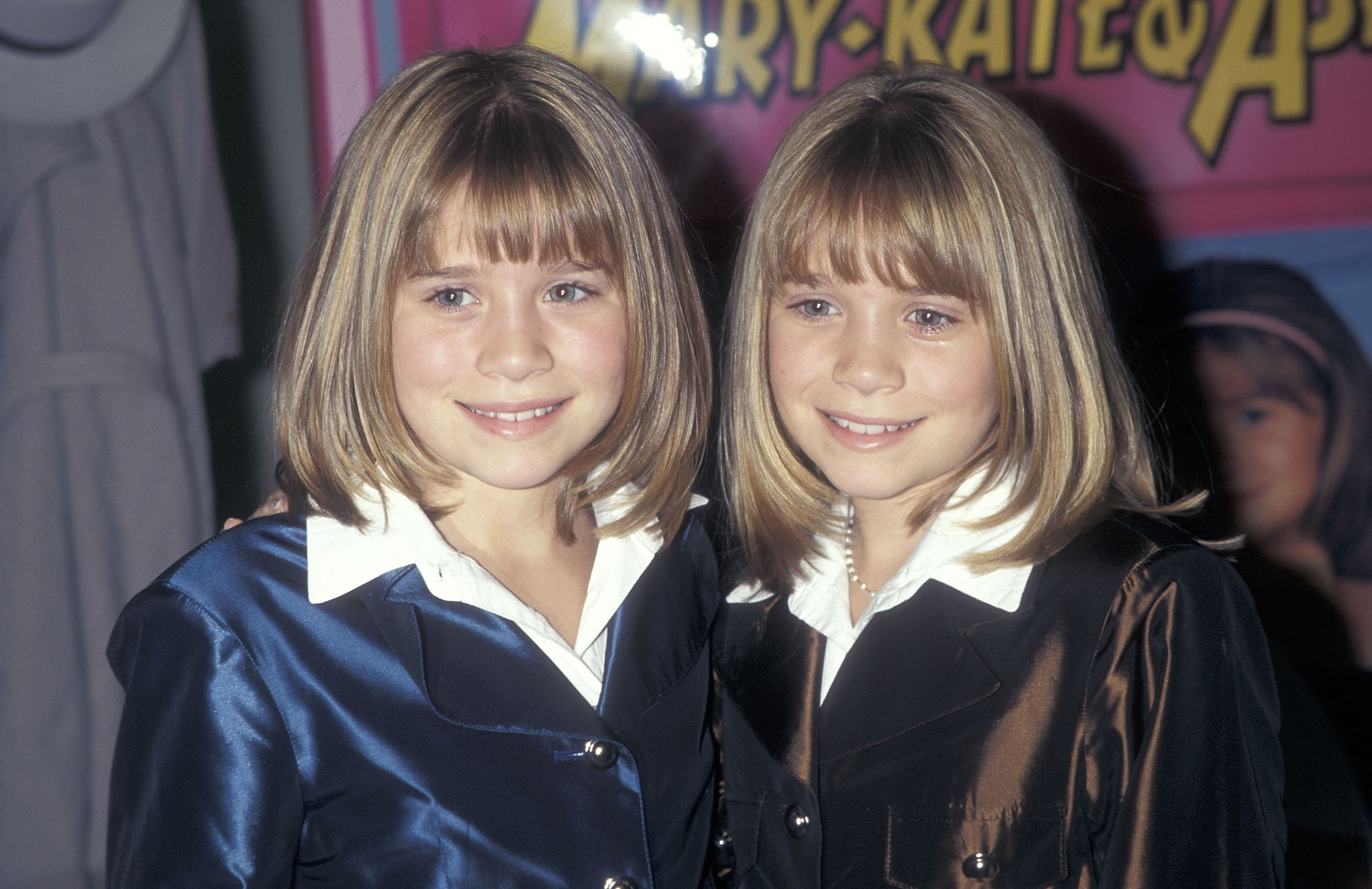 Their transition into polished teen pop icons was unmistakable during a book signing on January 17, 1998, where they debuted structured sapphire and bronze button-front jackets over crisp white collars, styled with sleek chin-length bobs and neat front bangs.