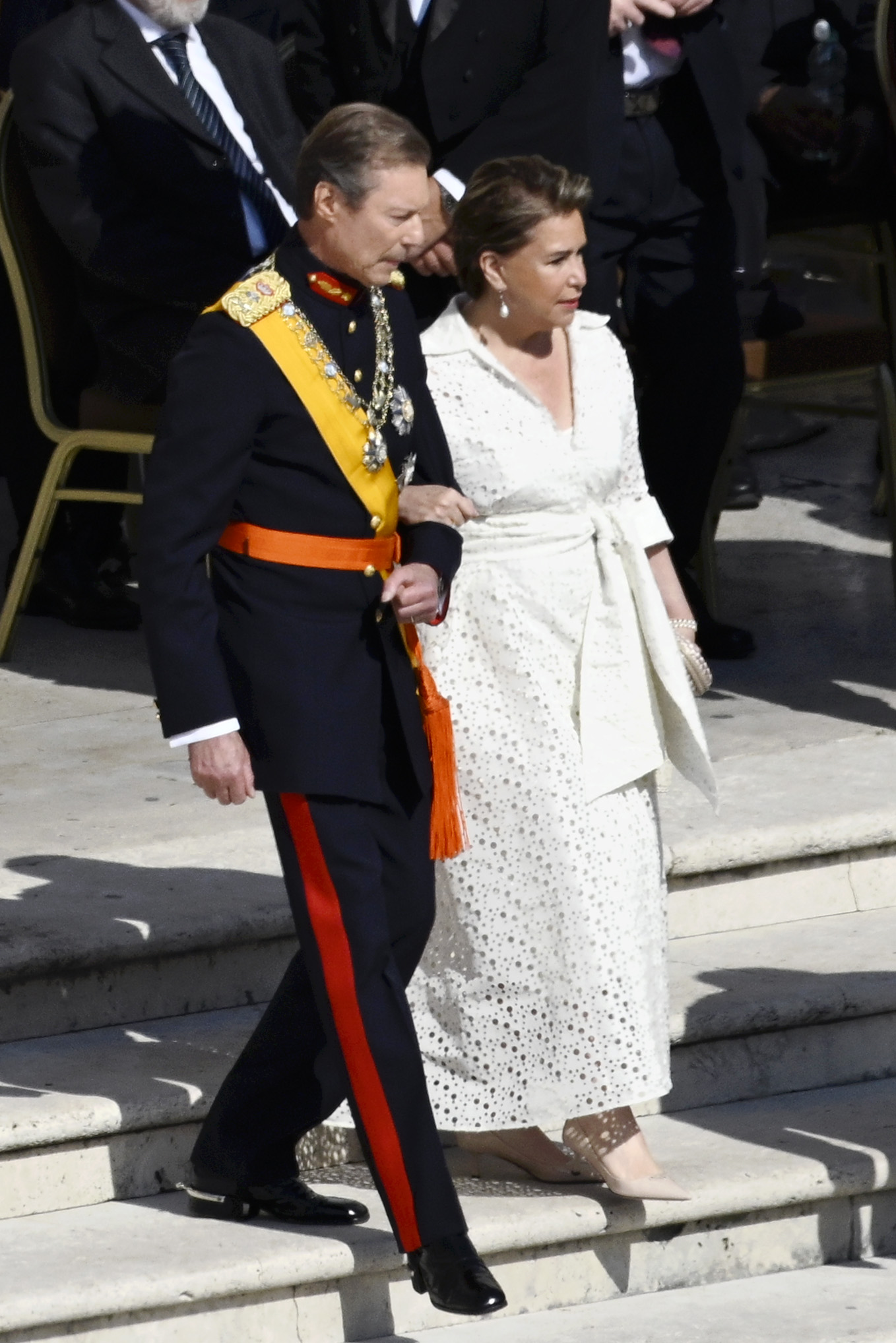 Grand Duke Henri of Luxembourg and Grand Duchess Maria Teresa of Luxembourg walk down the steps of St. Peter's Square on May 18, 2025, after attending the Vatican inauguration mass for Pope Leo XIV in ceremonial attire.