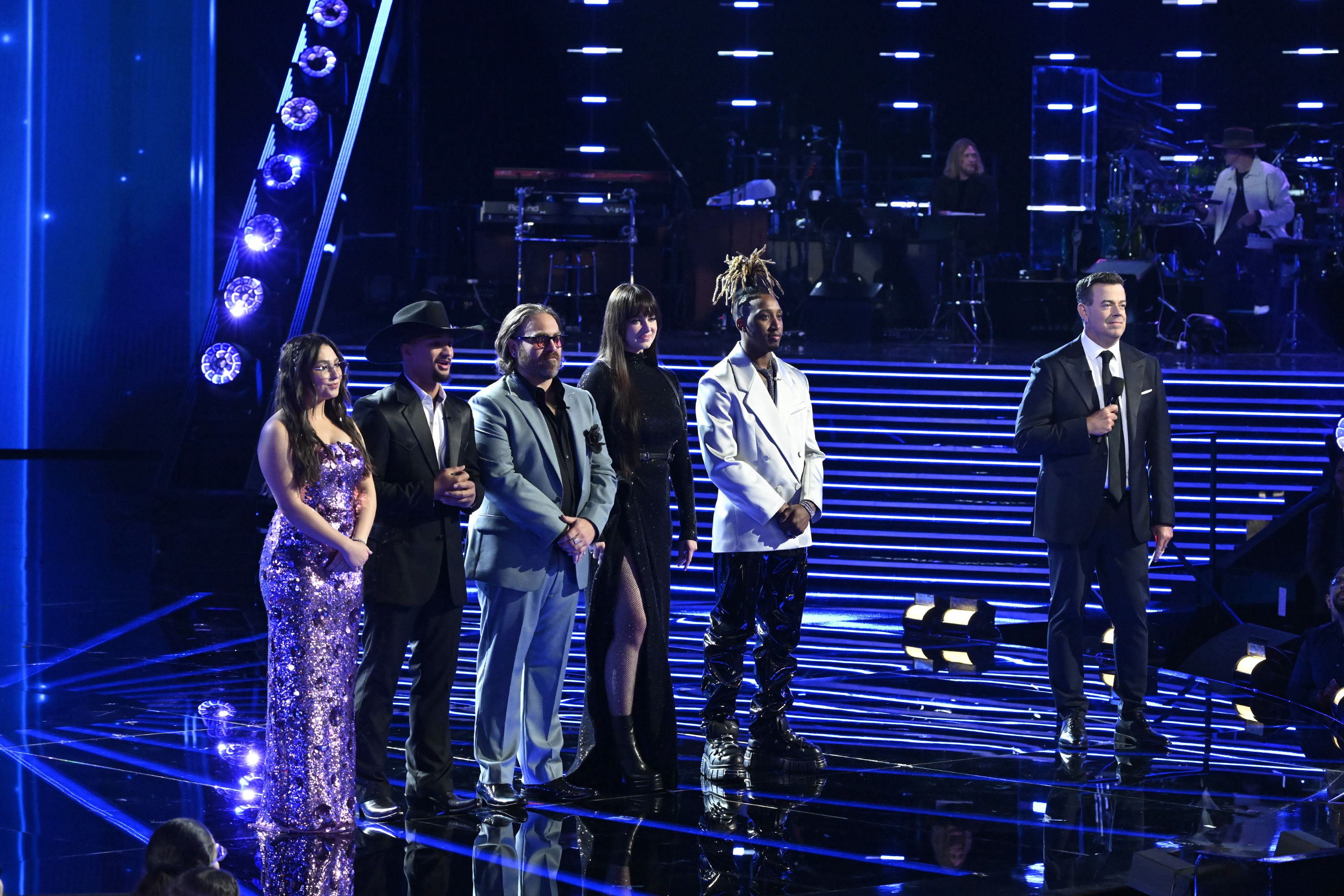 "The Voice" Season 27 finalists Lucia Flores-Wiseman, Jaelen Johnston, Adam David, Jadyn Cree, and Renzo, with host Carson Daly during the live finale on March 20, 2025 | Source: Getty Images