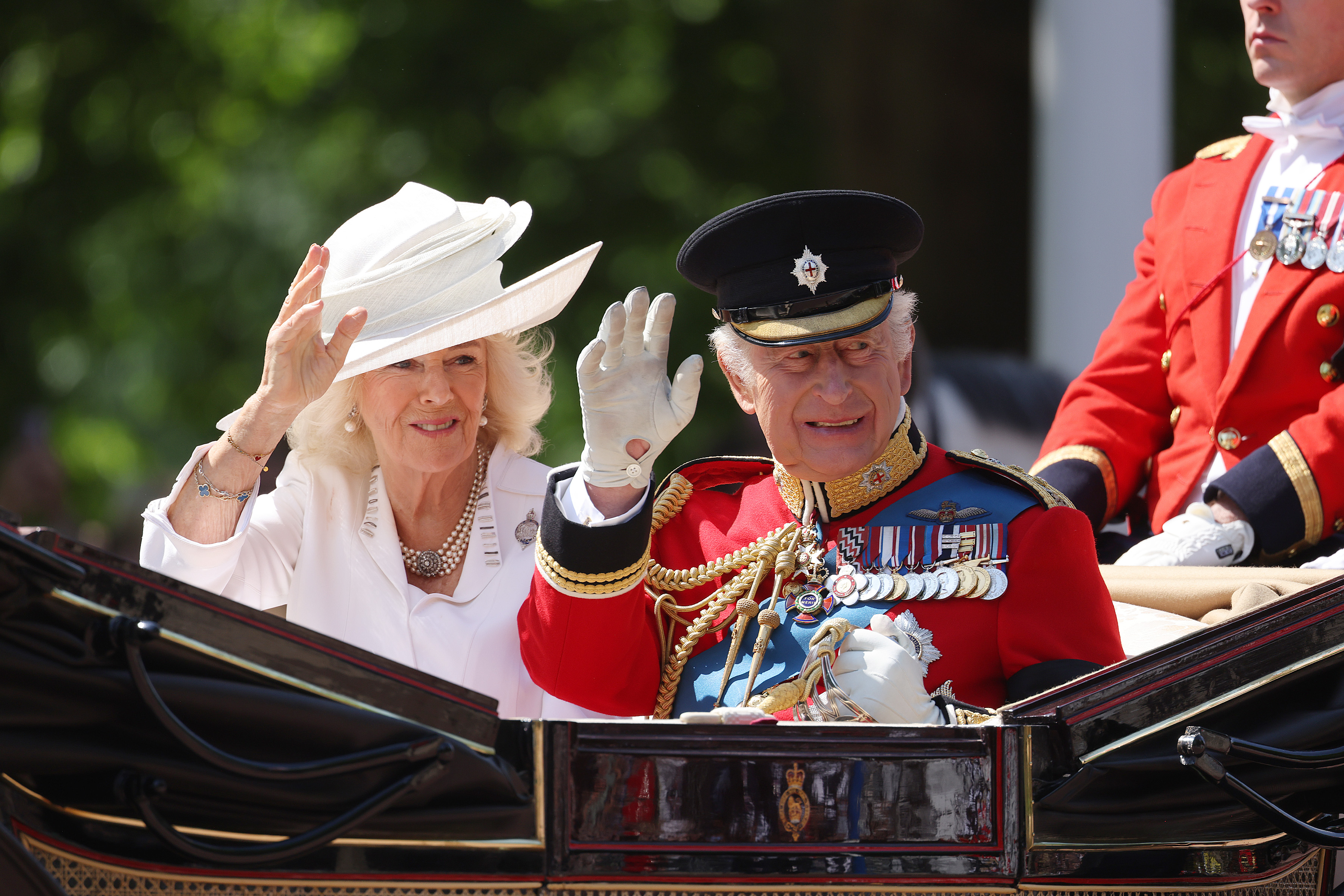 Queen Camilla and King Charles III riding in their carriage and greeting onlookers during Trooping the Colour. | Source: Getty Images
