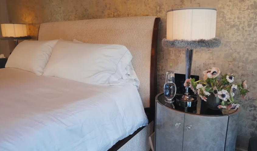 The bed area keeps the room grounded and soft. After the home's bolder moments, this corner feels especially peaceful. | Source: YouTube/Architectural Digest