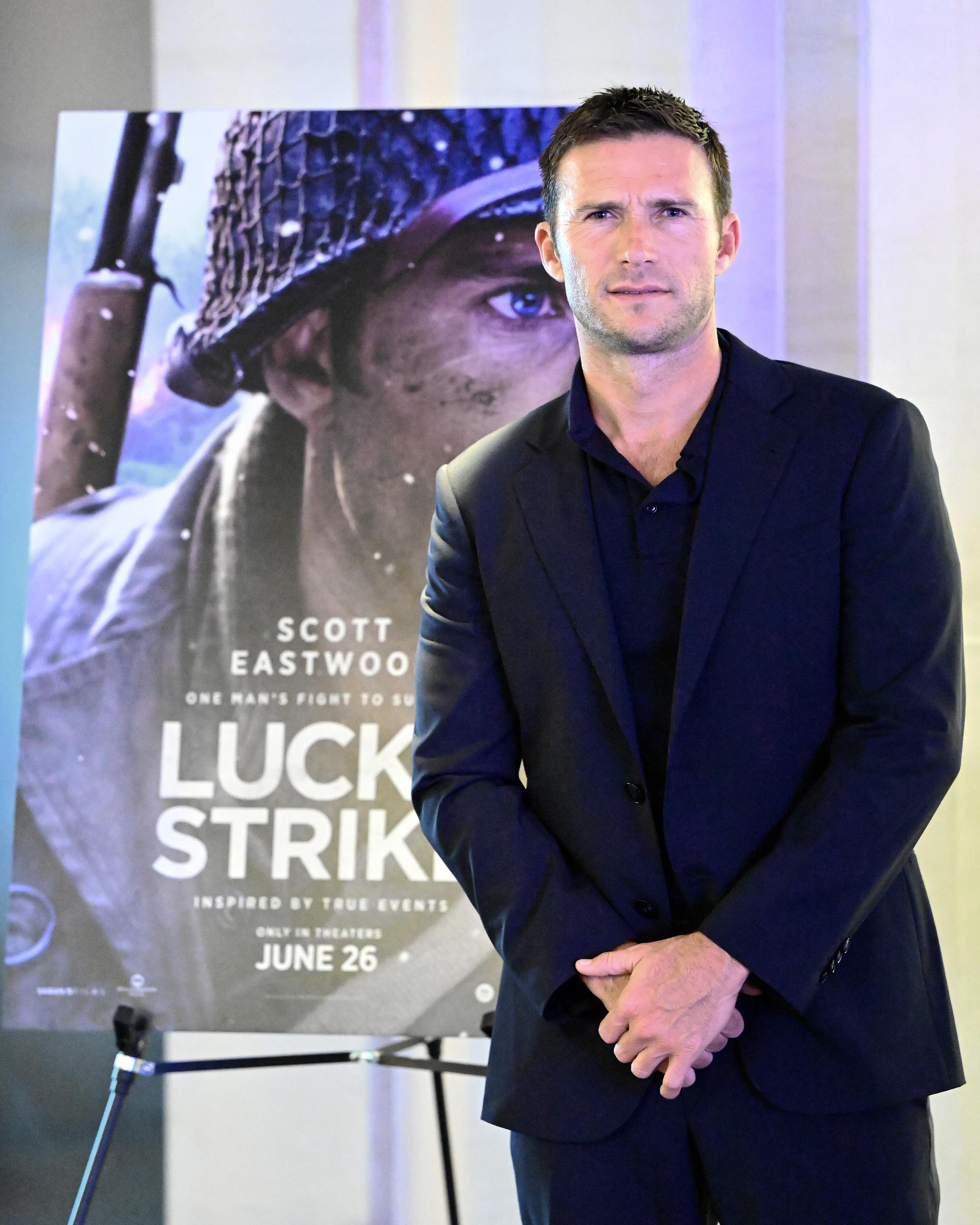 Scott Eastwood attended a screening of "Lucky Strike" at the National Archives Museum in Washington, D.C., on June 8, 2026, posing in a dark navy suit beside a poster featuring his character from the film. With his short hair neatly styled and his blue eyes catching the light, Scott's furrowed brow and defined facial features were especially prominent in the portrait. The appearance came as the actor continued building a screen career of his own.