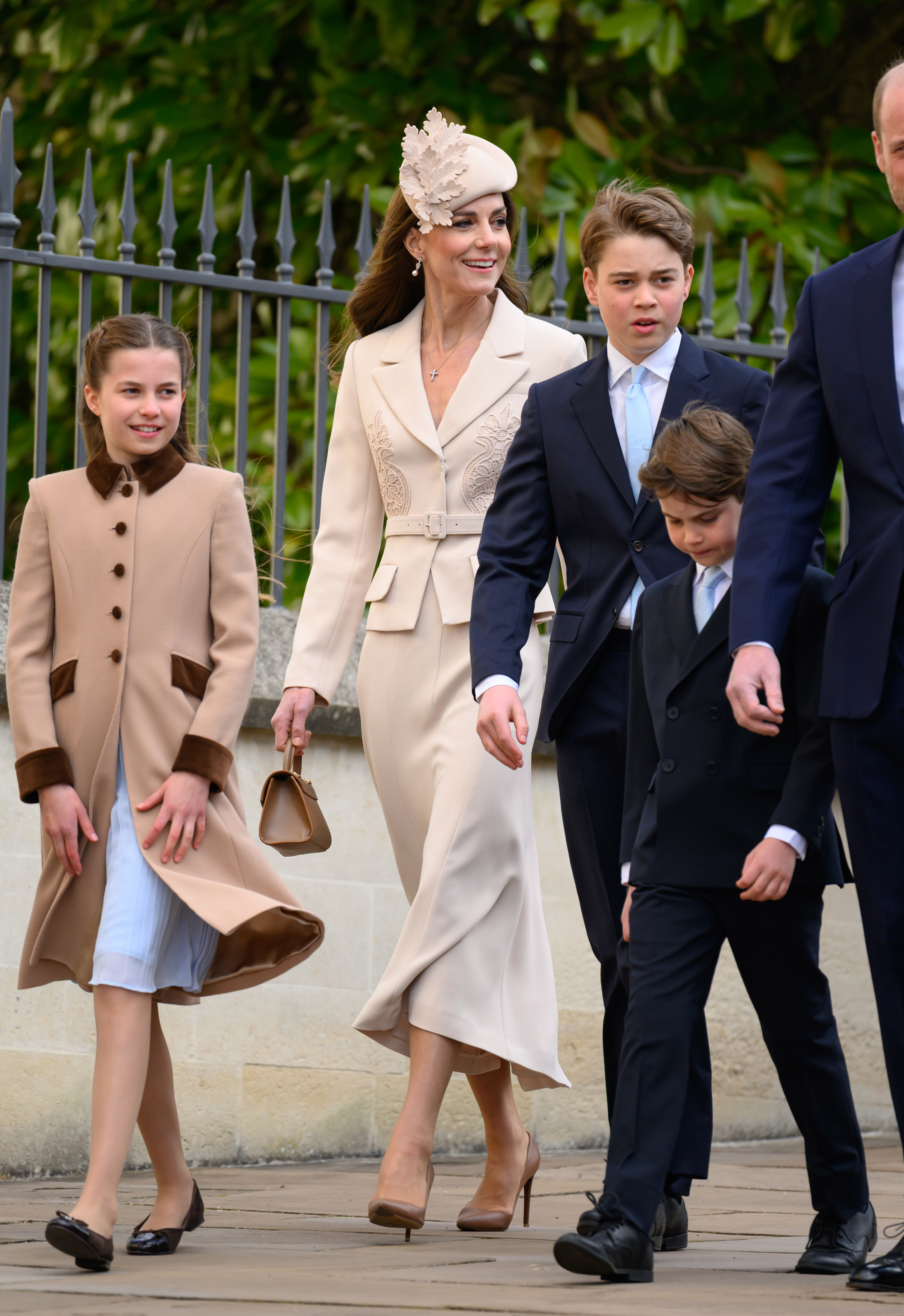 The whole Wales family in step at Windsor, and the photo that explains everything. Princess Charlotte strides out to the left in her camel coat while the Princess of Wales walks at the centre. And then there is Prince George standing head and shoulders above Prince Louis and drawing level with his mother, the Prince of Wales visible just behind them both. | Source: Getty Images