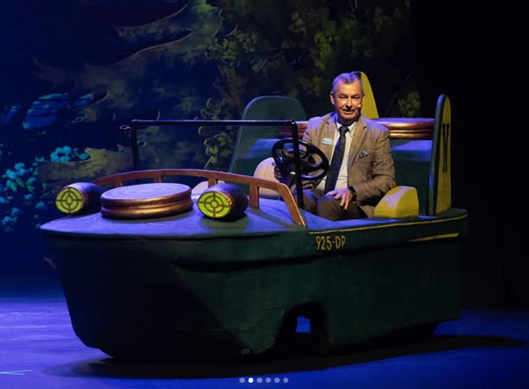 Dollywood President Eugene Naughton rode onto the stage in a themed prop vehicle during the NightFlight Expedition ceremony. Parton later joined the event by video after missing the celebration in person.  | Source: Instagram/dollywood