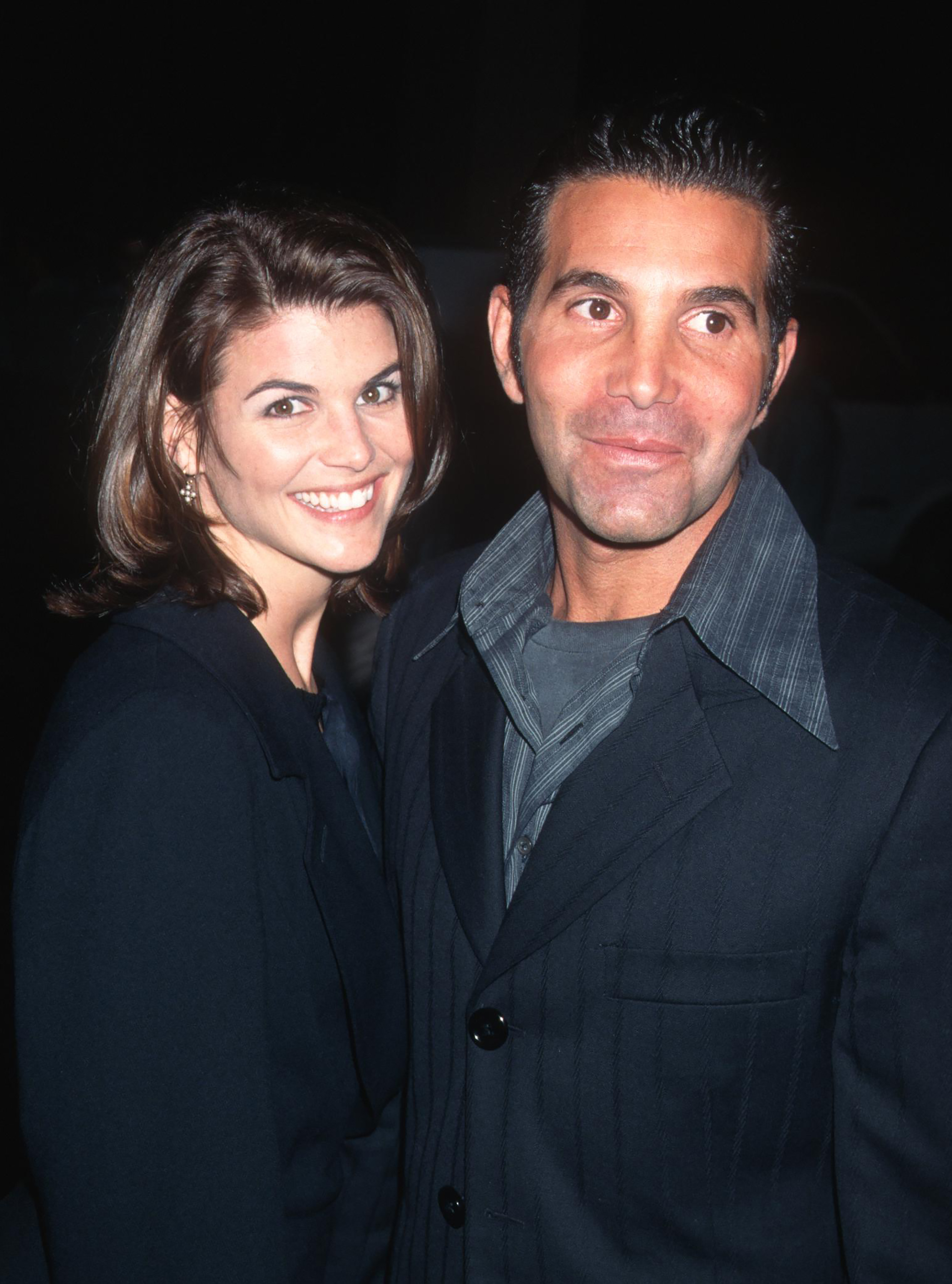 Lori Loughlin and Mossimo Giannulli are pictured at the GQ Magazine cocktail party honoring Peter Bart at the Beverly Hills Hotel in Beverly Hills, California, on December 12, 1995, smiling together for the camera. | Source: Getty Images