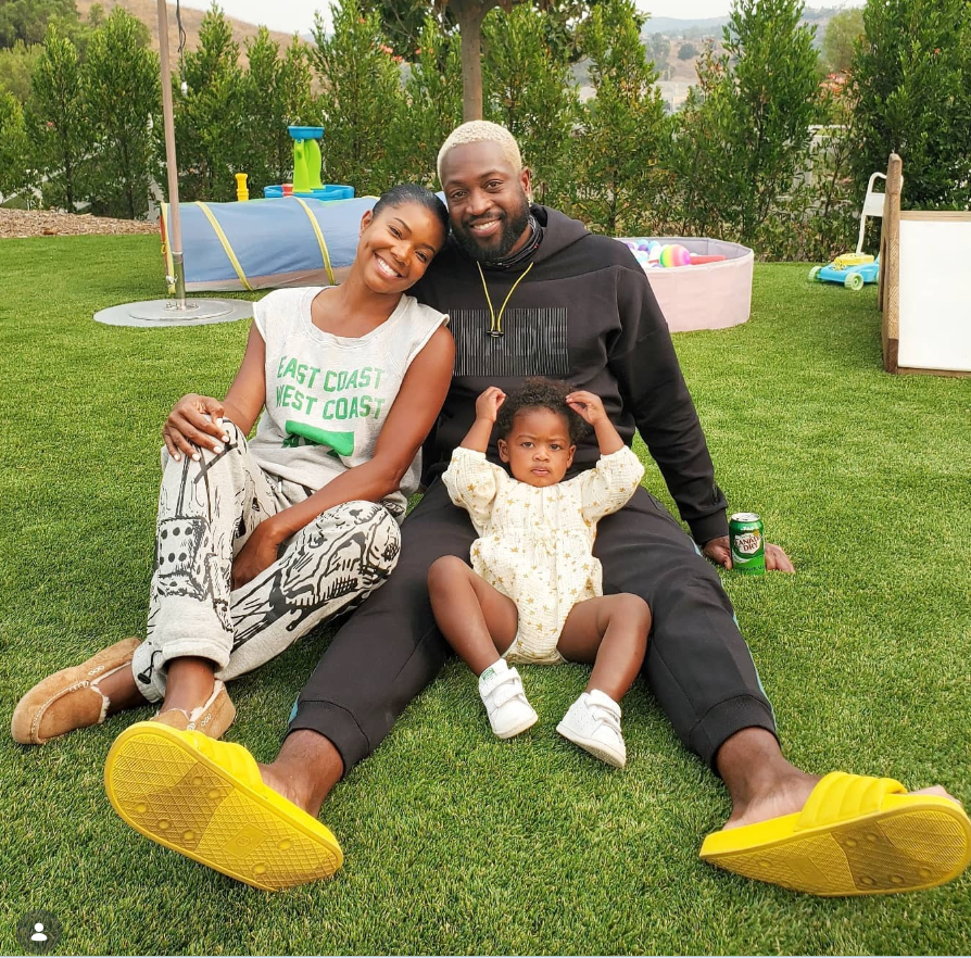 Gabrielle Union sits on a lush green lawn beside Dwyane Wade, with their daughter Kaavia James Union Wade nestled between them. | Source: Instagram/gabunion