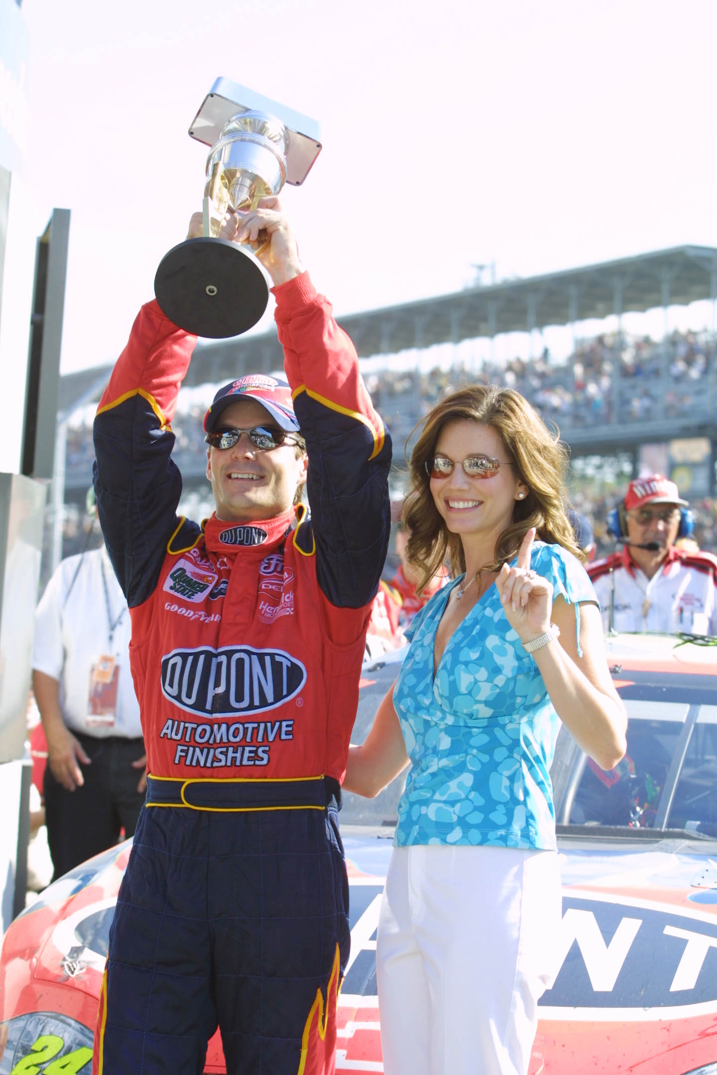 Jeff Gordon raised the winner's trophy as Brooke Sealey celebrated beside him following his victory in the NASCAR Winston Cup Brickyard 400 at Indianapolis Motor Speedway on August 5, 2001. Sealey's raised finger echoed her husband's first-place finish, captured less than a year before their eight-year marriage came to an end.